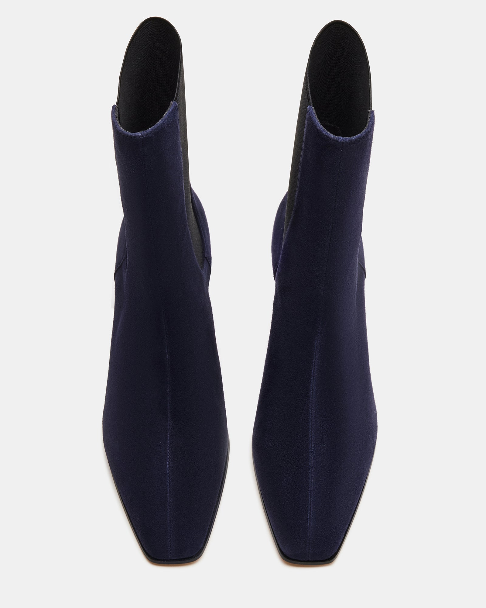Close-up of navy suede cowboy boots showing square toe and textured heel.
