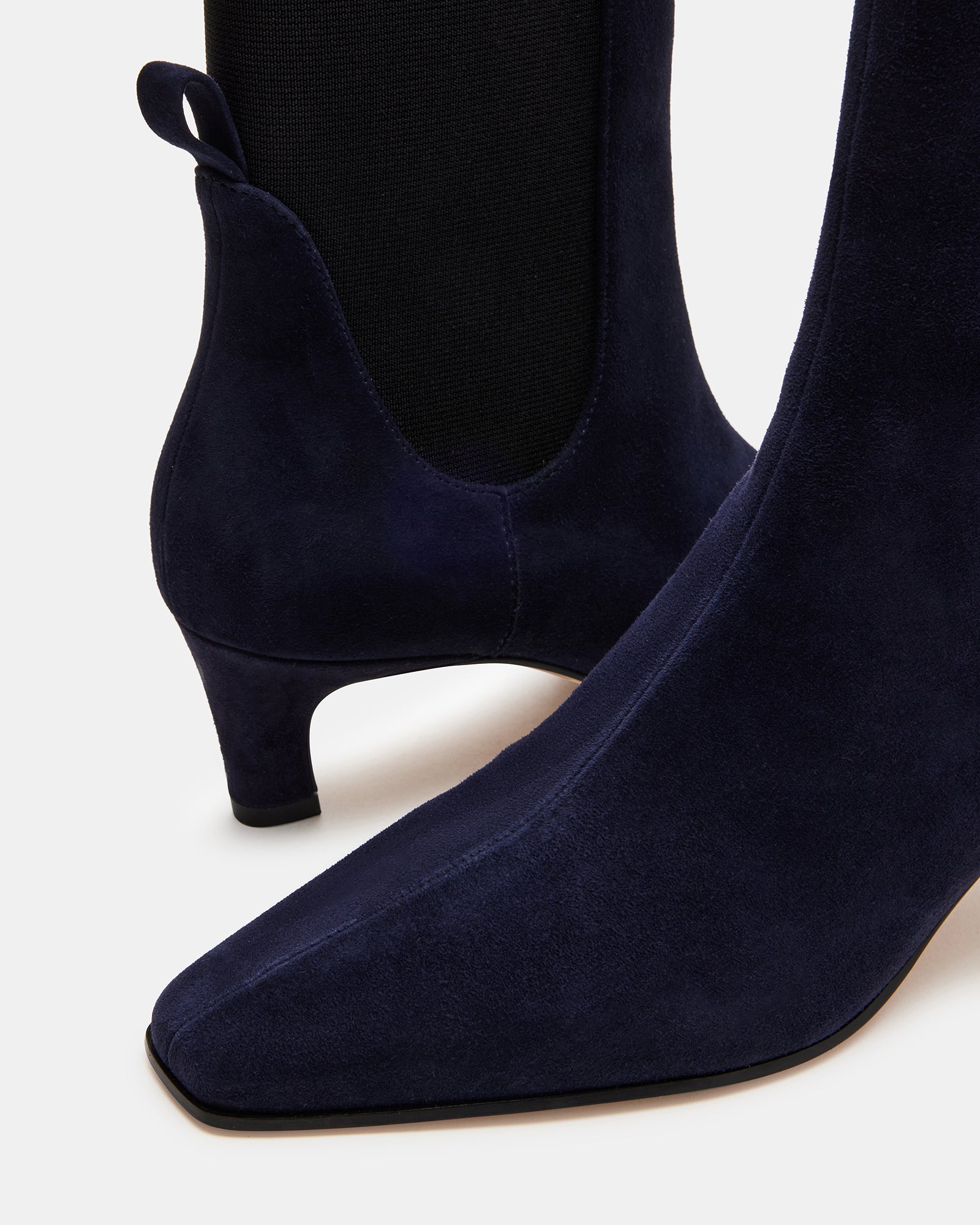 Brown suede boots shown under warm lighting for fall-ready aesthetic.