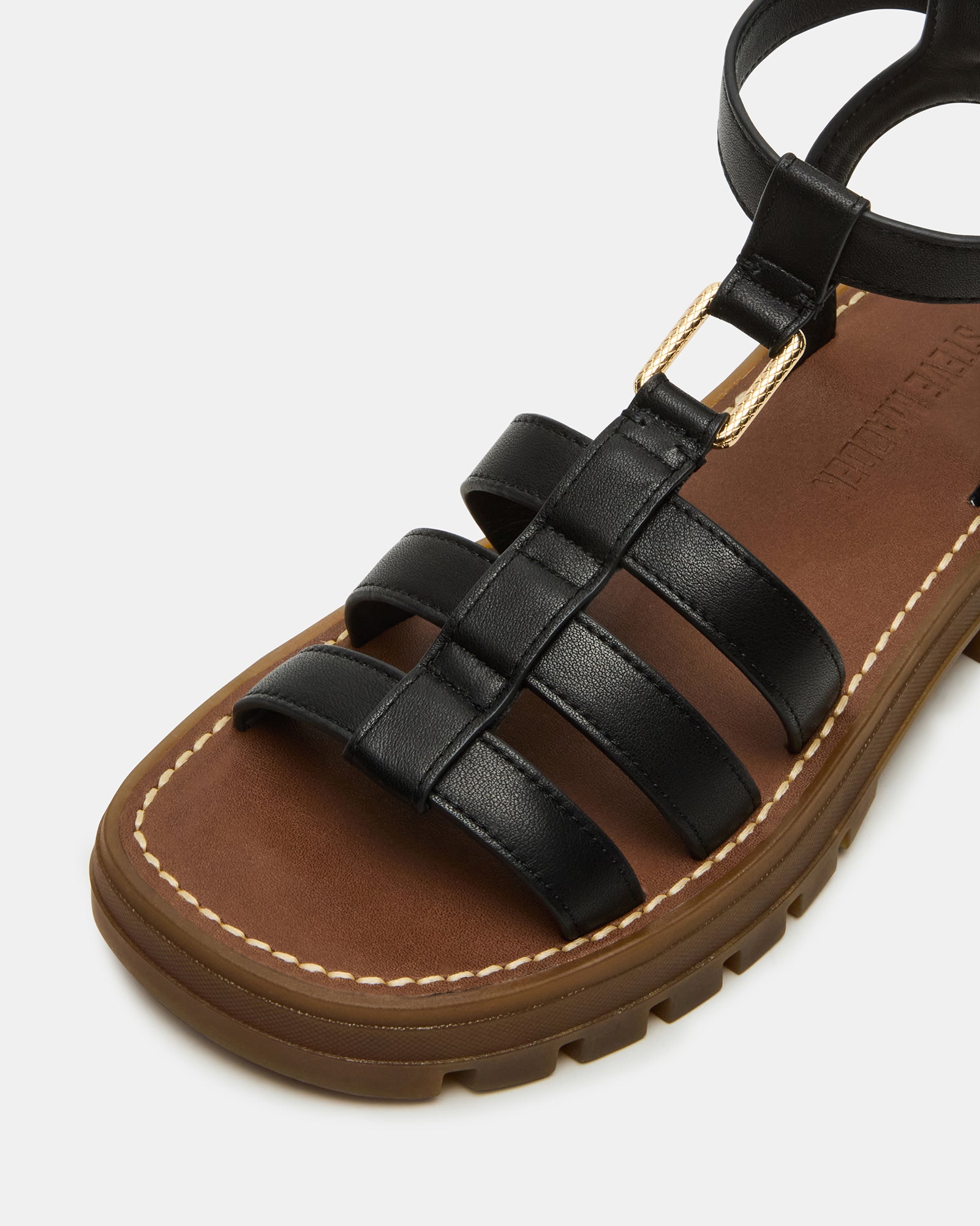 Close-up of black strappy sandals showcasing the leather detail and square toe design.