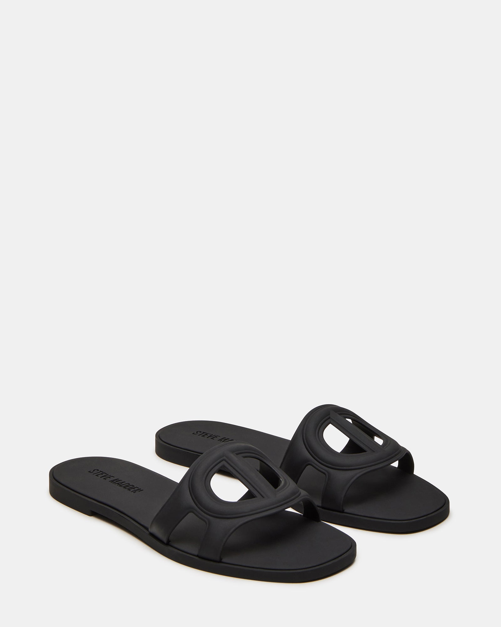 JELLIE black slide sandals displayed in a stylish outdoor environment.