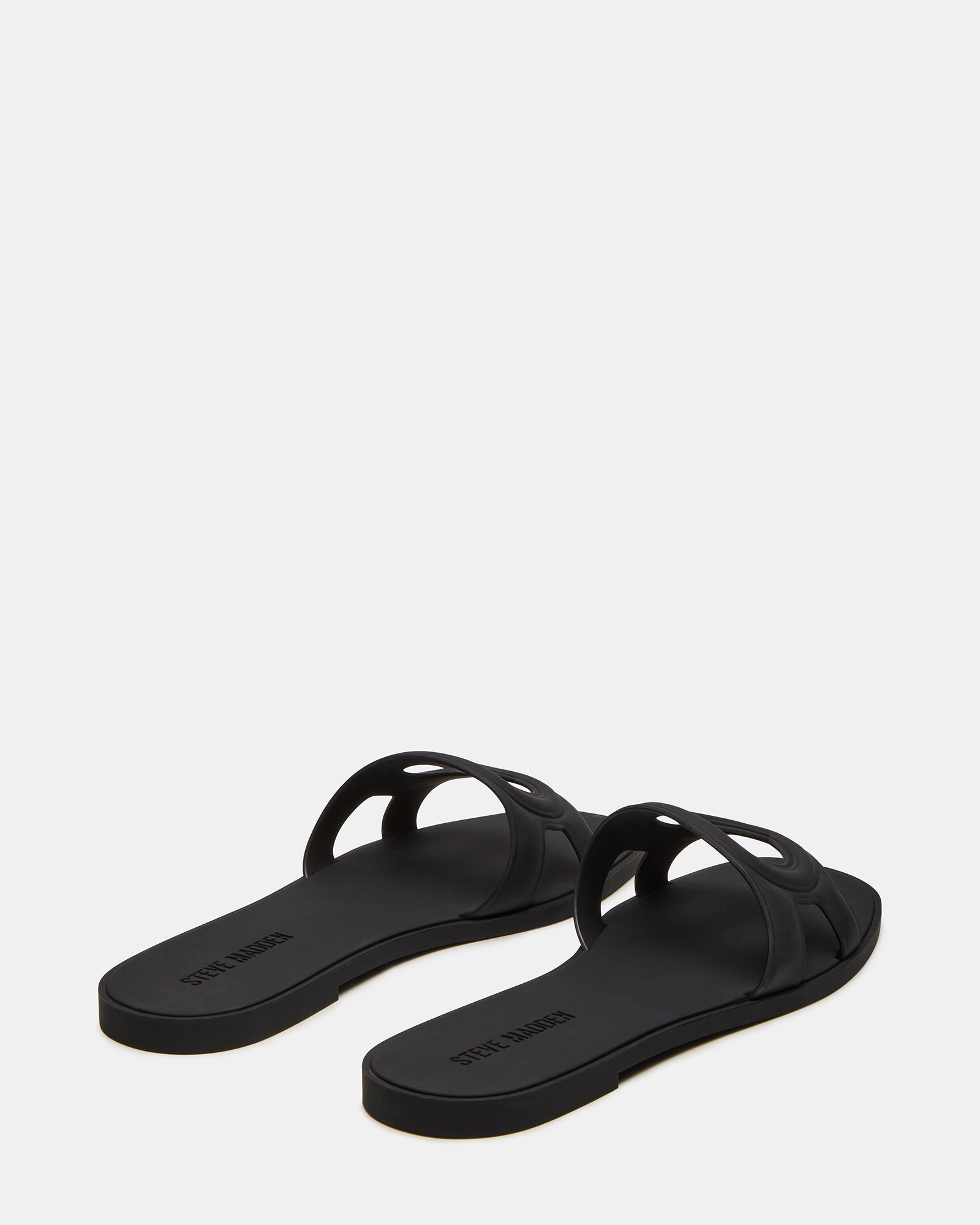 JELLIE black slide sandals displayed in a stylish outdoor environment.