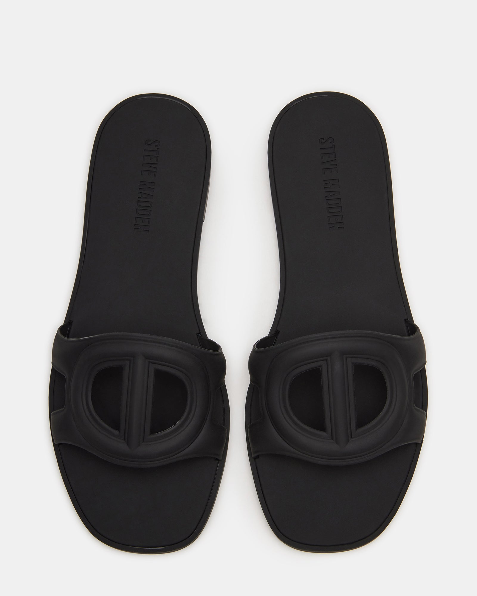 JELLIE black slide sandals worn casually in a park setting.