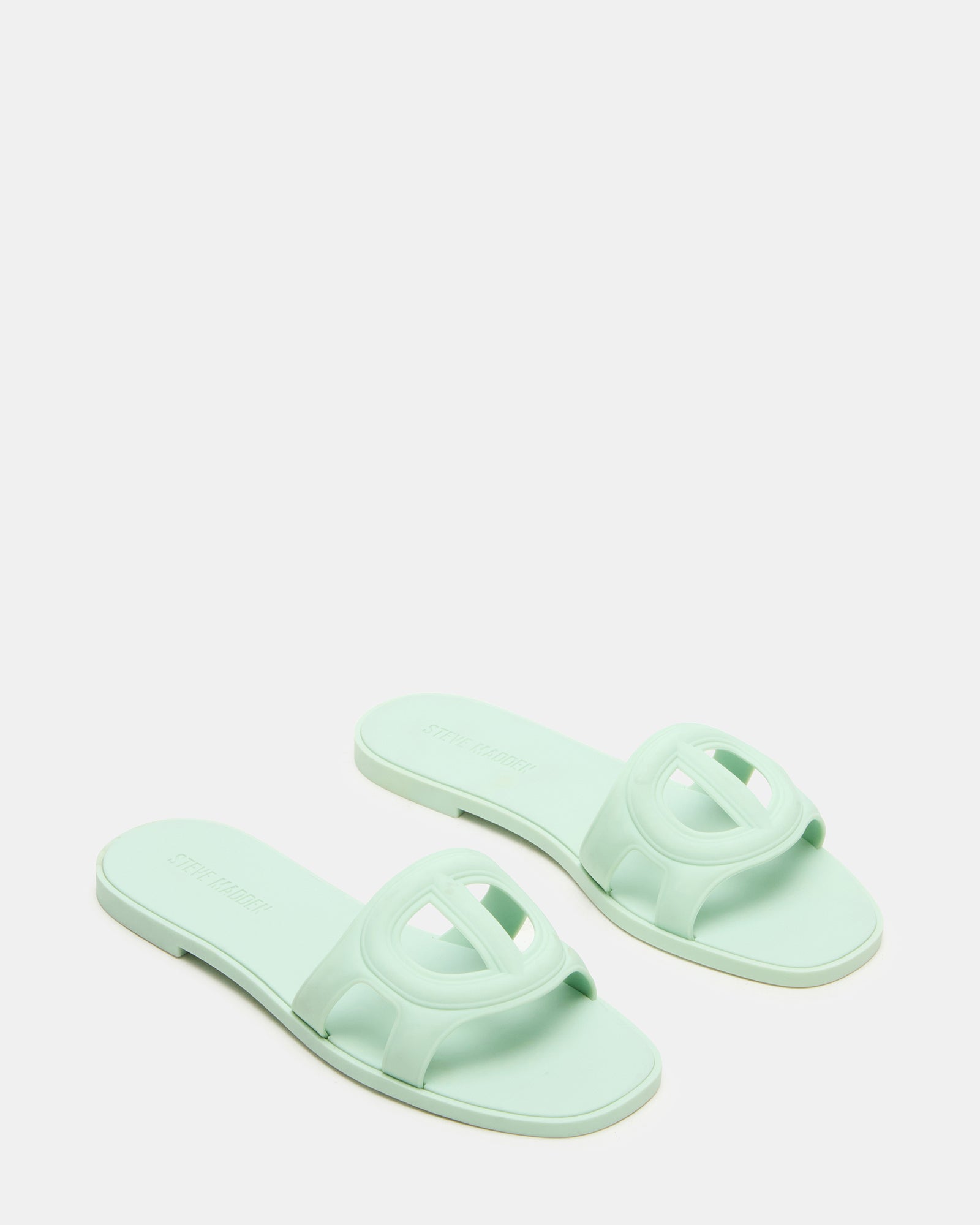 Close-up of black flat sandals showing textured sole and sleek design.