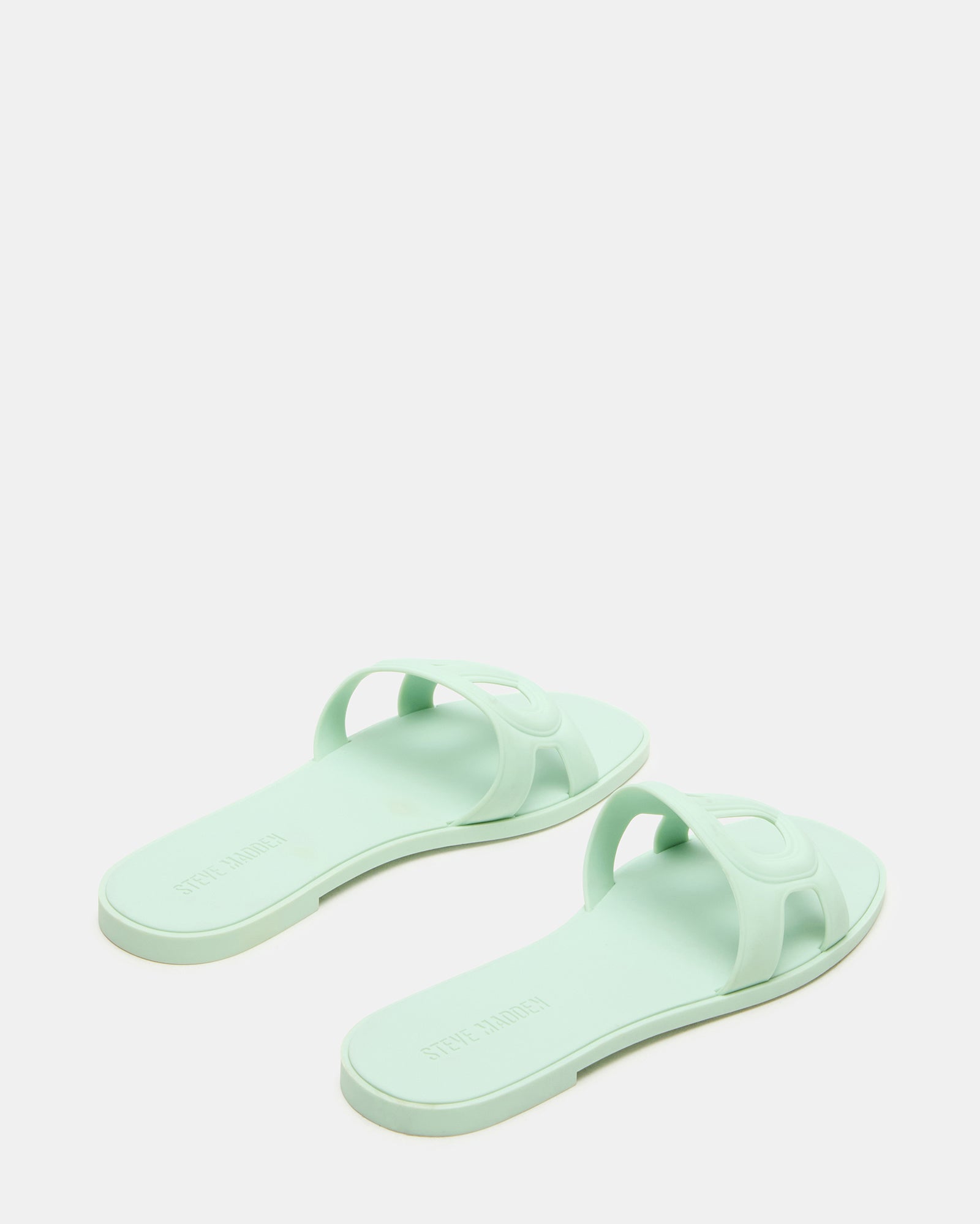 Close-up of black flat sandals showing textured sole and sleek design.