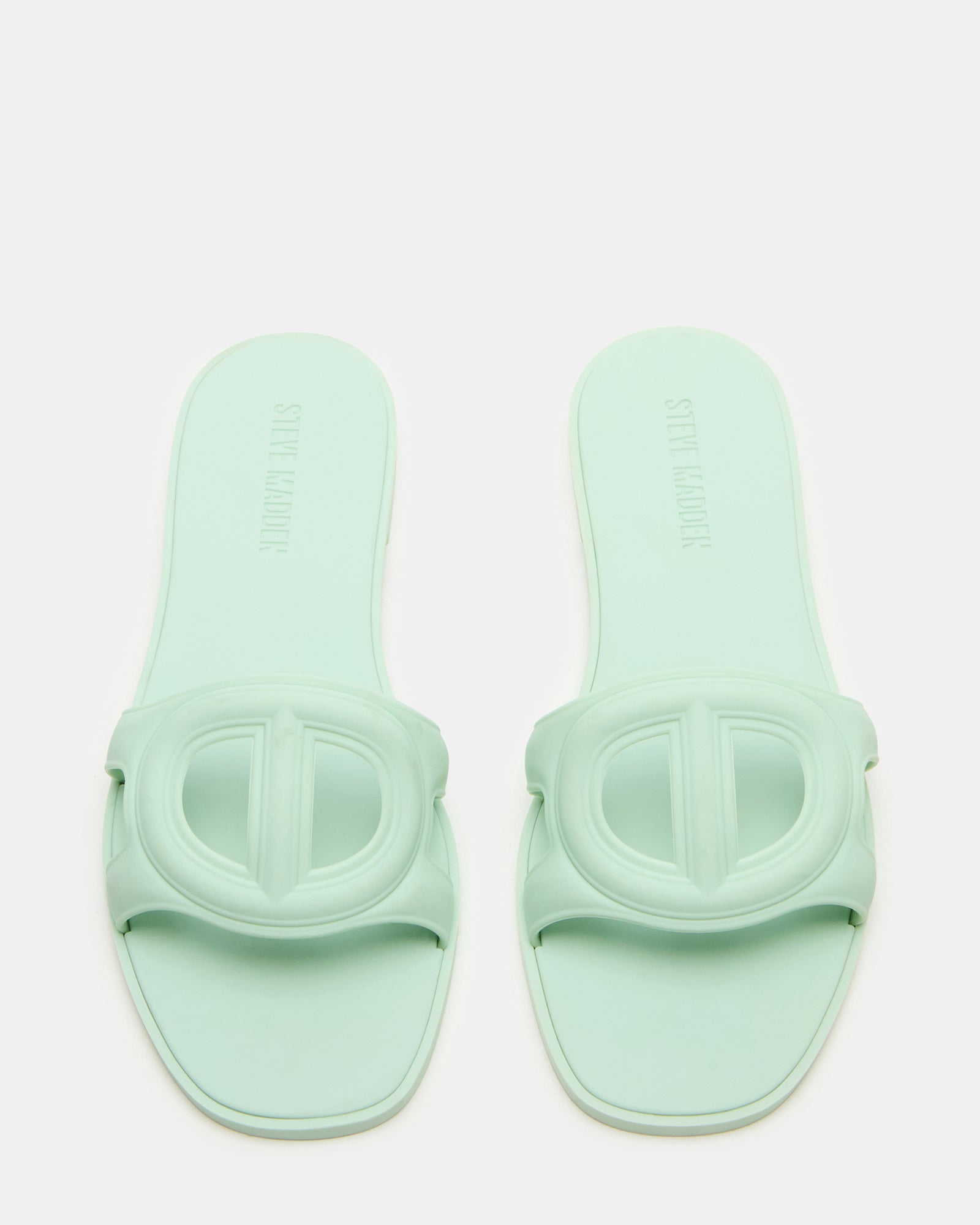 Jellie Pistachio gold flat sandals on a wooden deck, perfect for summer outings.