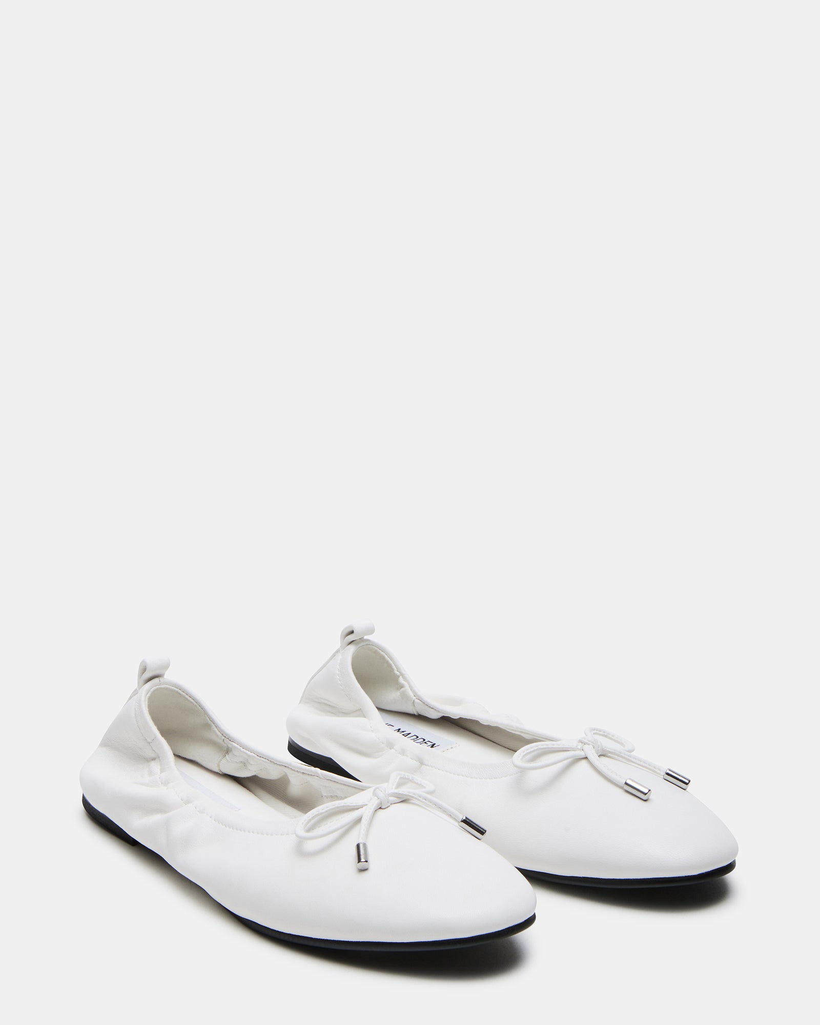Side view of the stylish Jester white leather ballet flats worn in a casual setting.