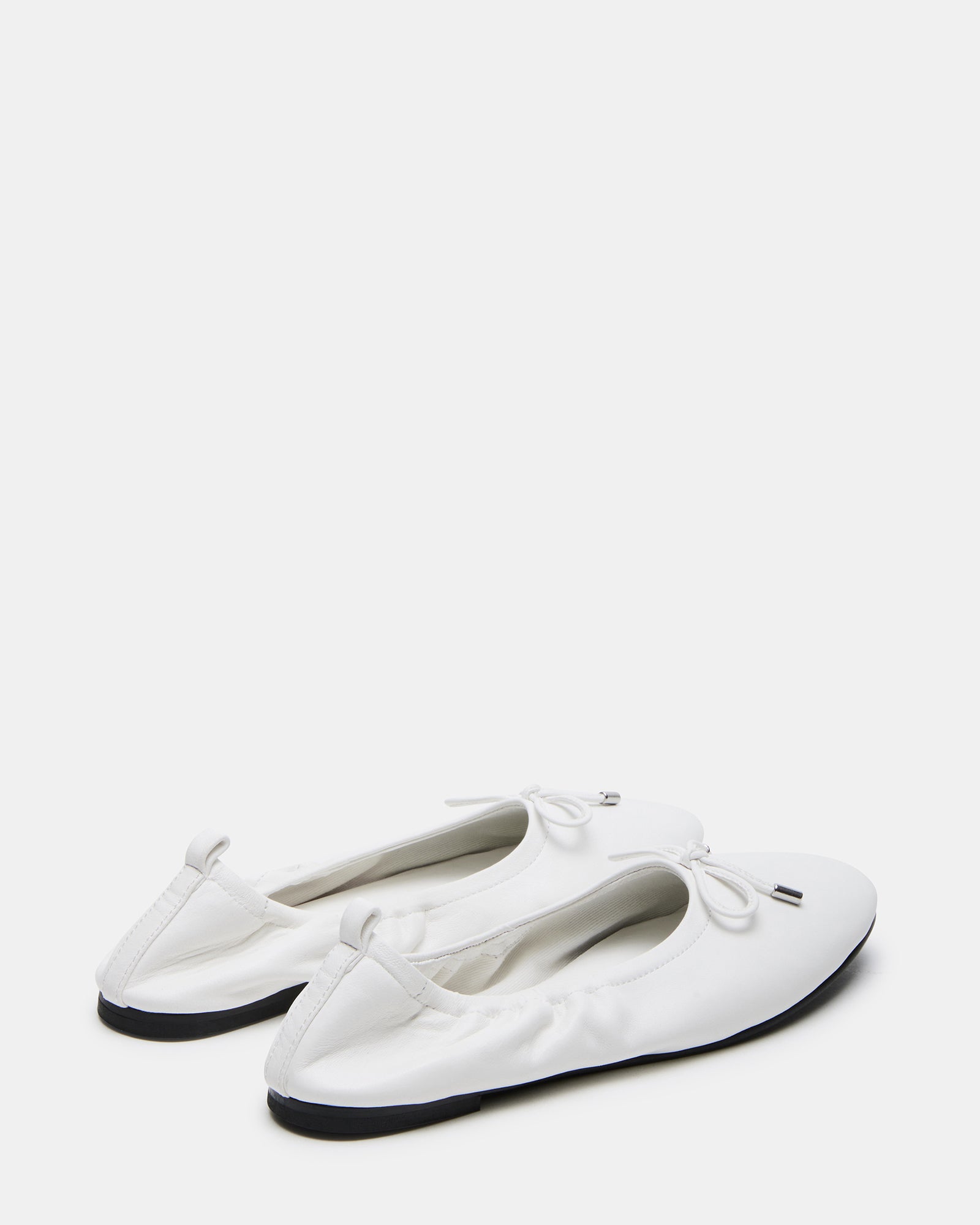 Side view of the stylish Jester white leather ballet flats worn in a casual setting.