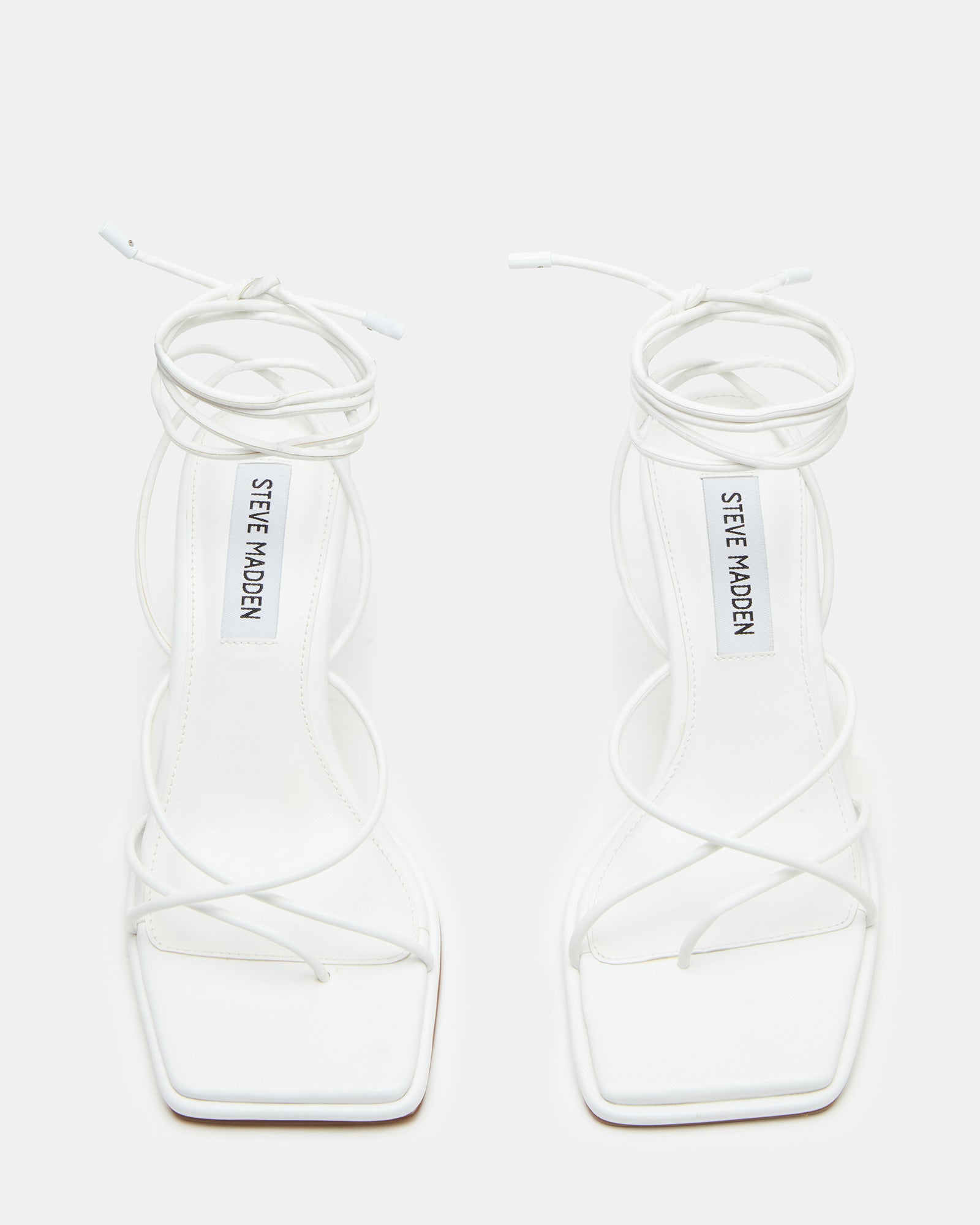 Close-up of adjustable ankle straps on white heels
