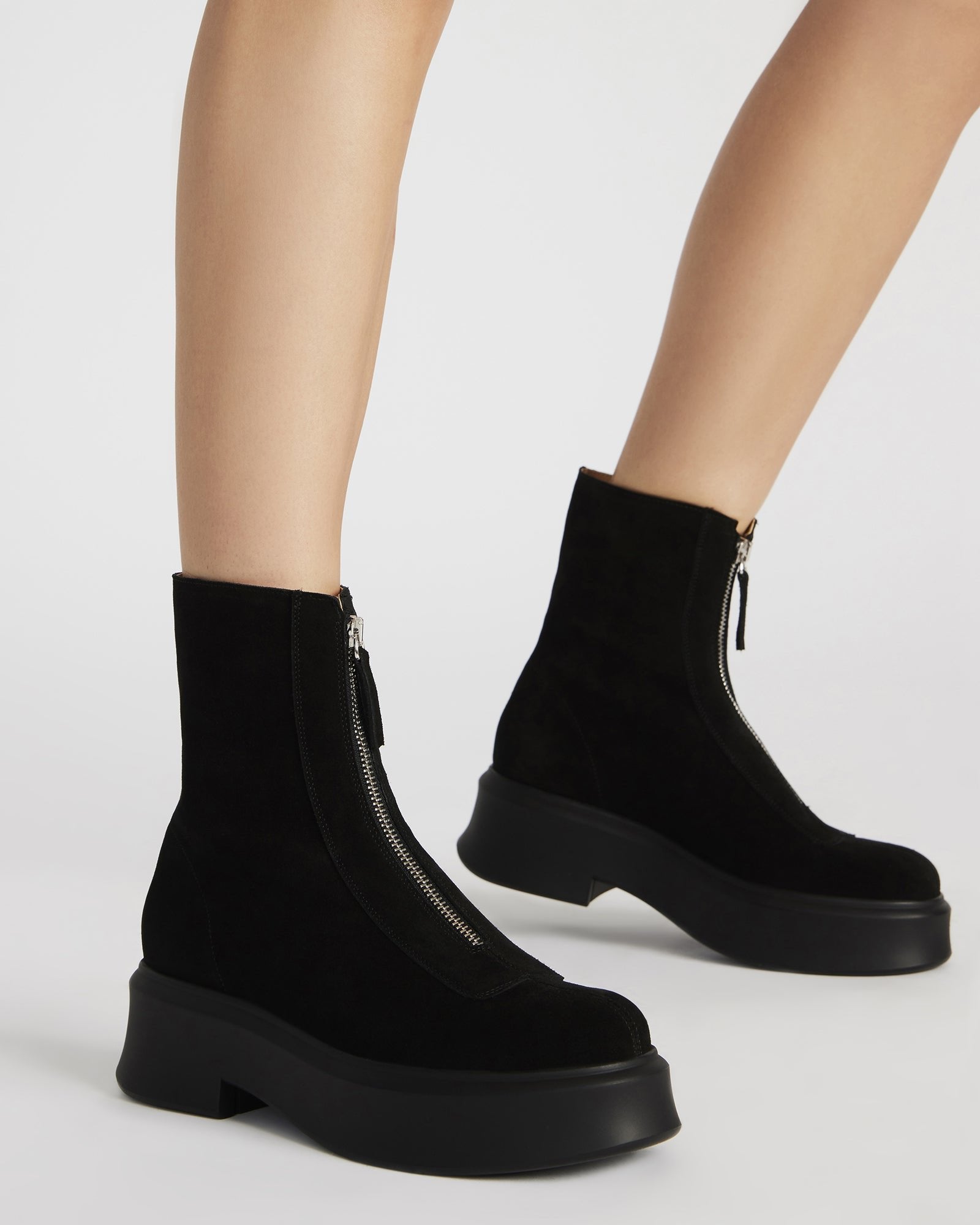 Model wearing navy suede ankle boots paired with casual outfit.