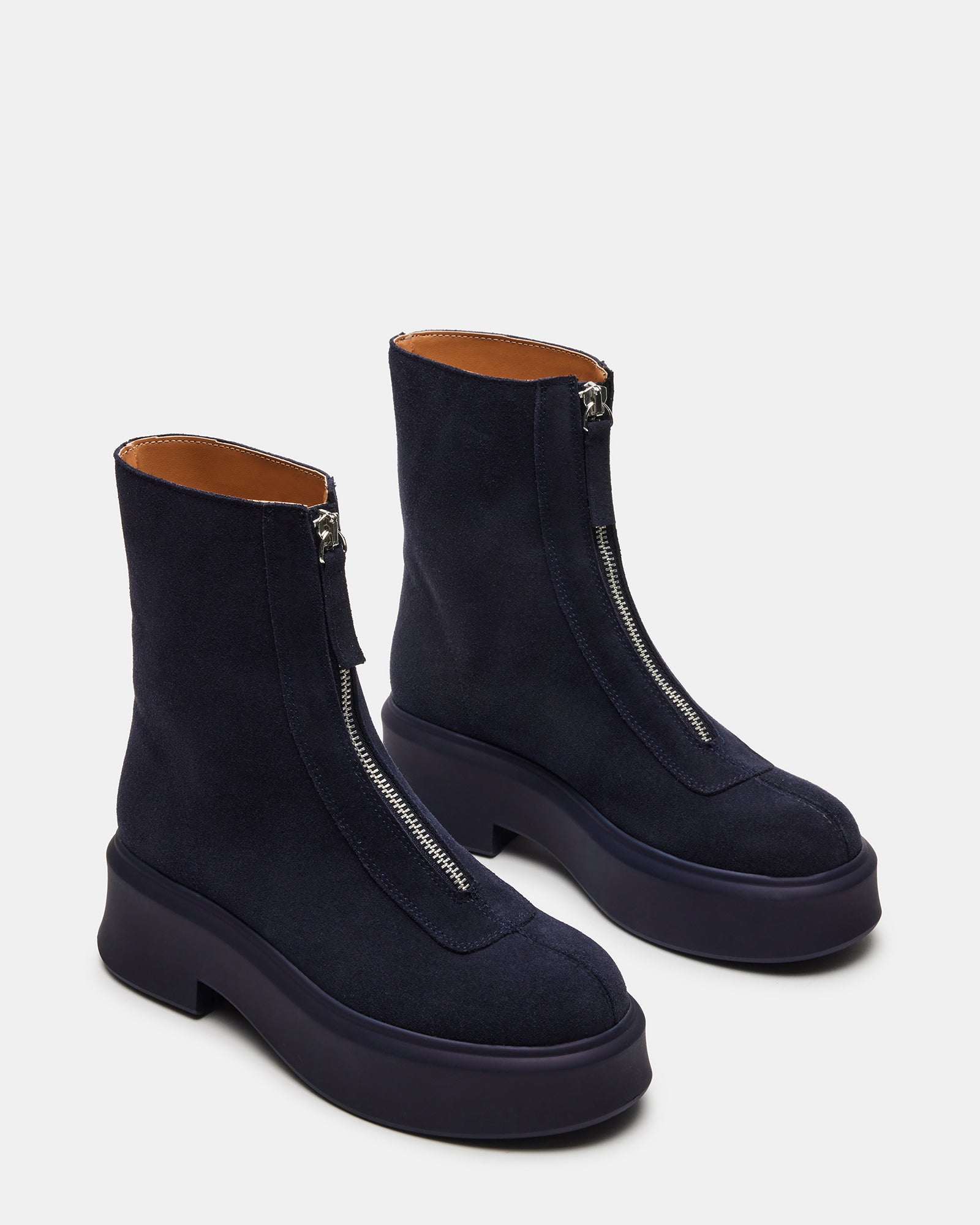 Close-up of front zipper detail on stylish navy ankle booties.