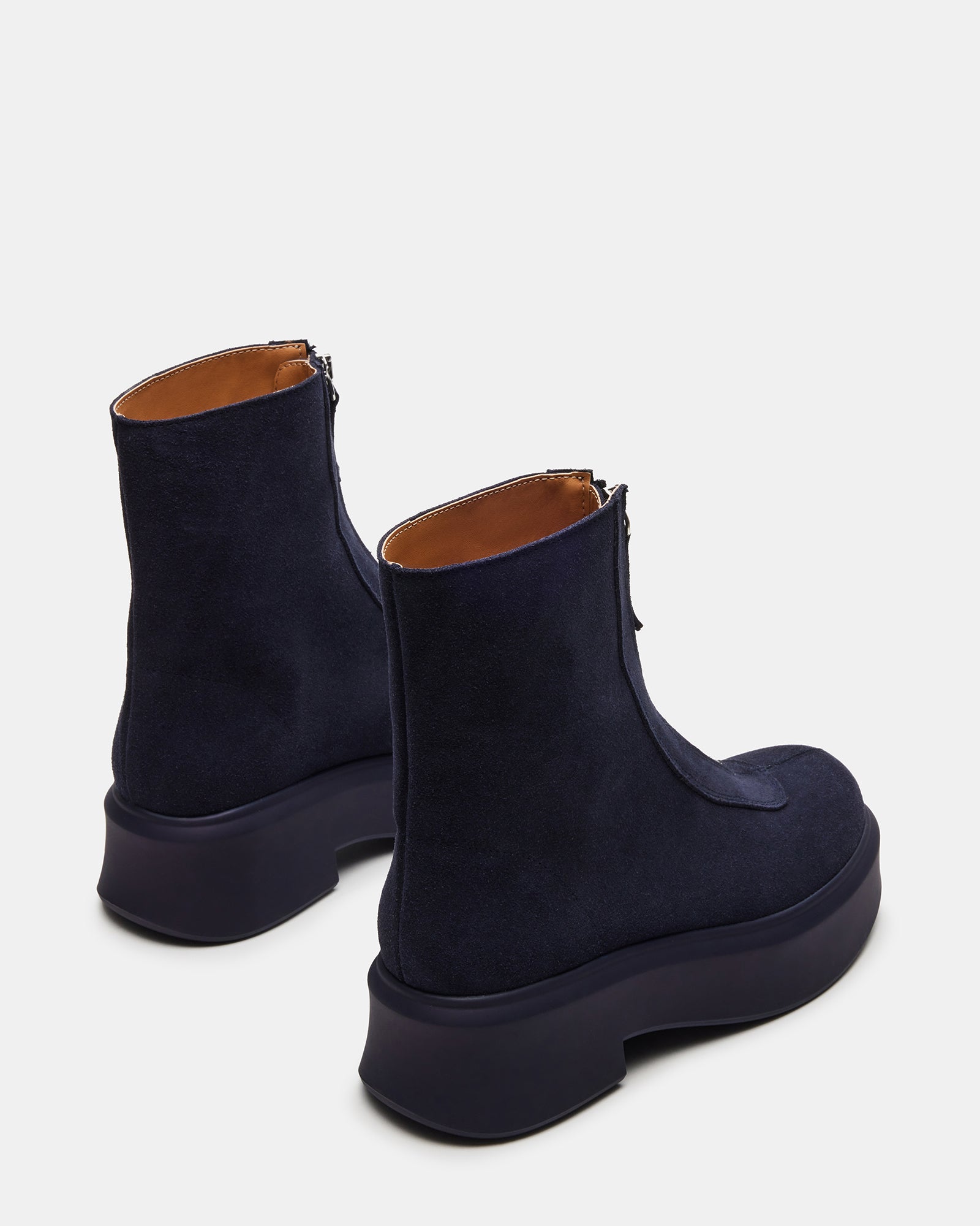Close-up of front zipper detail on stylish navy ankle booties.