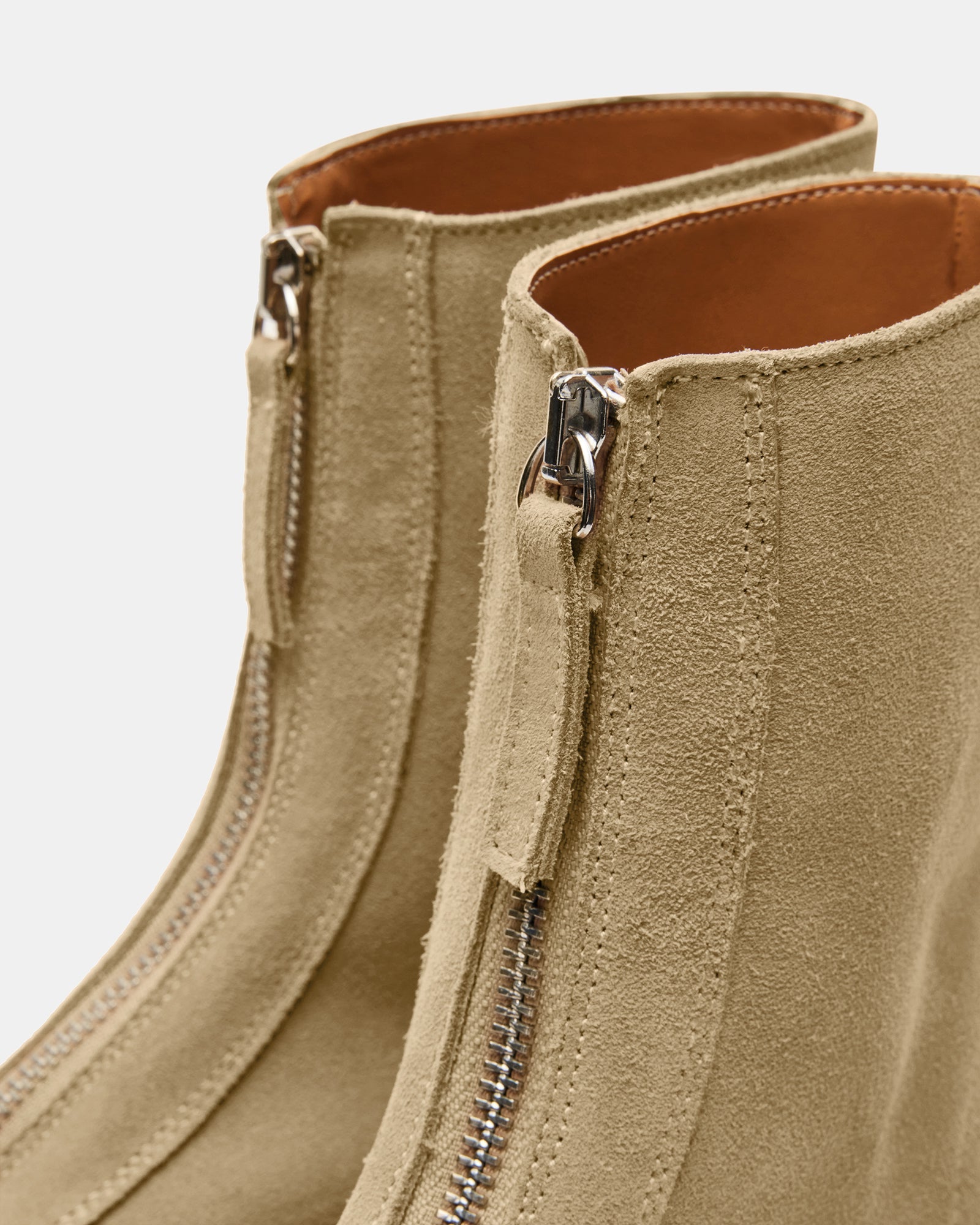 Side view of JONES tan suede ankle boots showcasing the heel and zipper detail