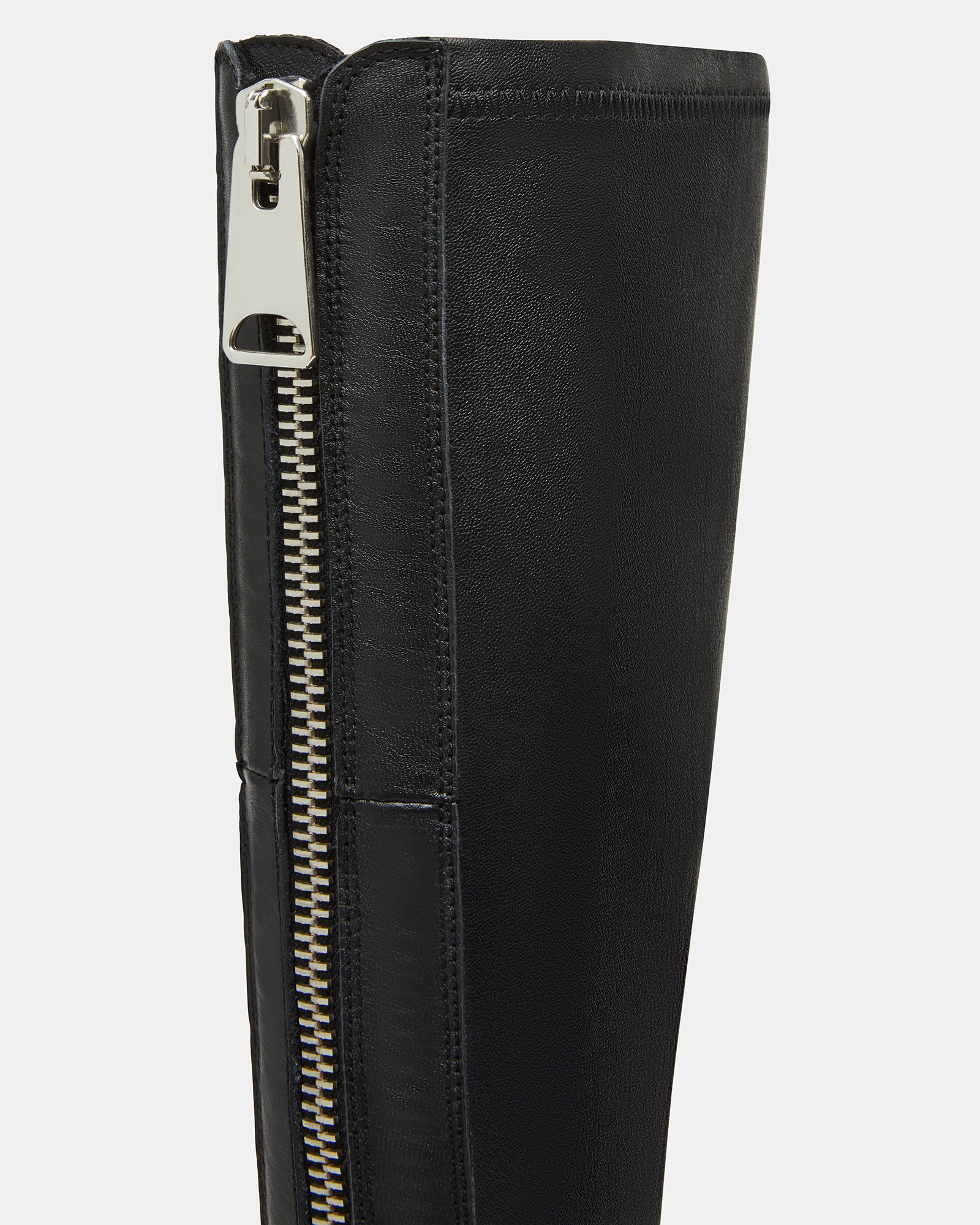 Close-up of the durable sole of knee-high black boots.