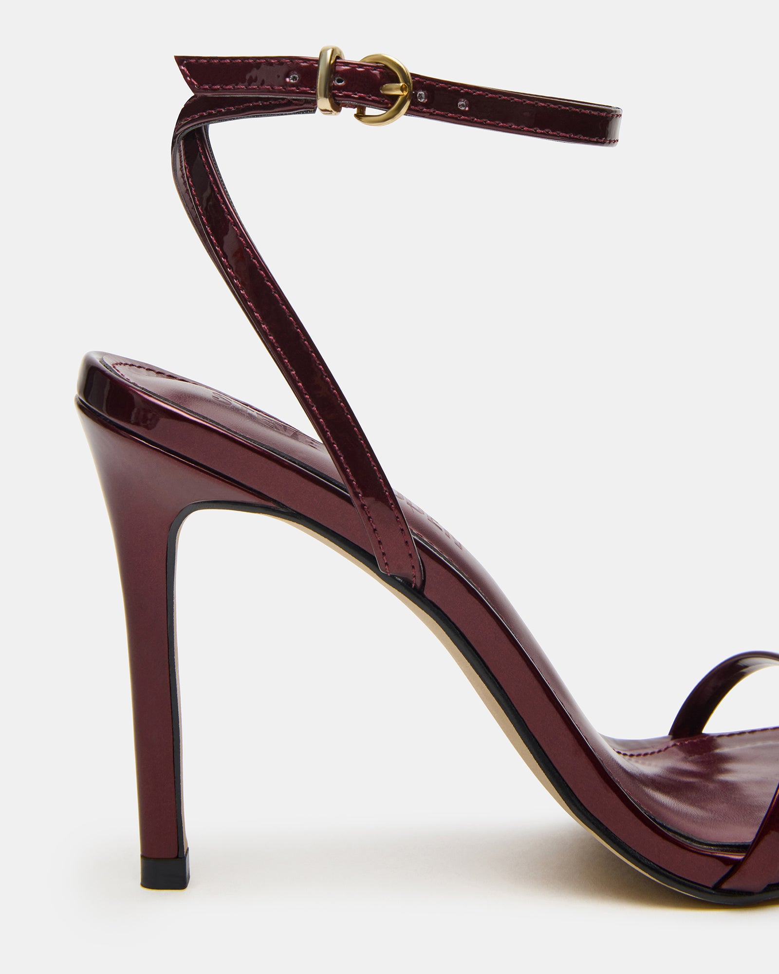 Gold JYPSY stiletto heels on hardwood floor, showcasing ankle strap