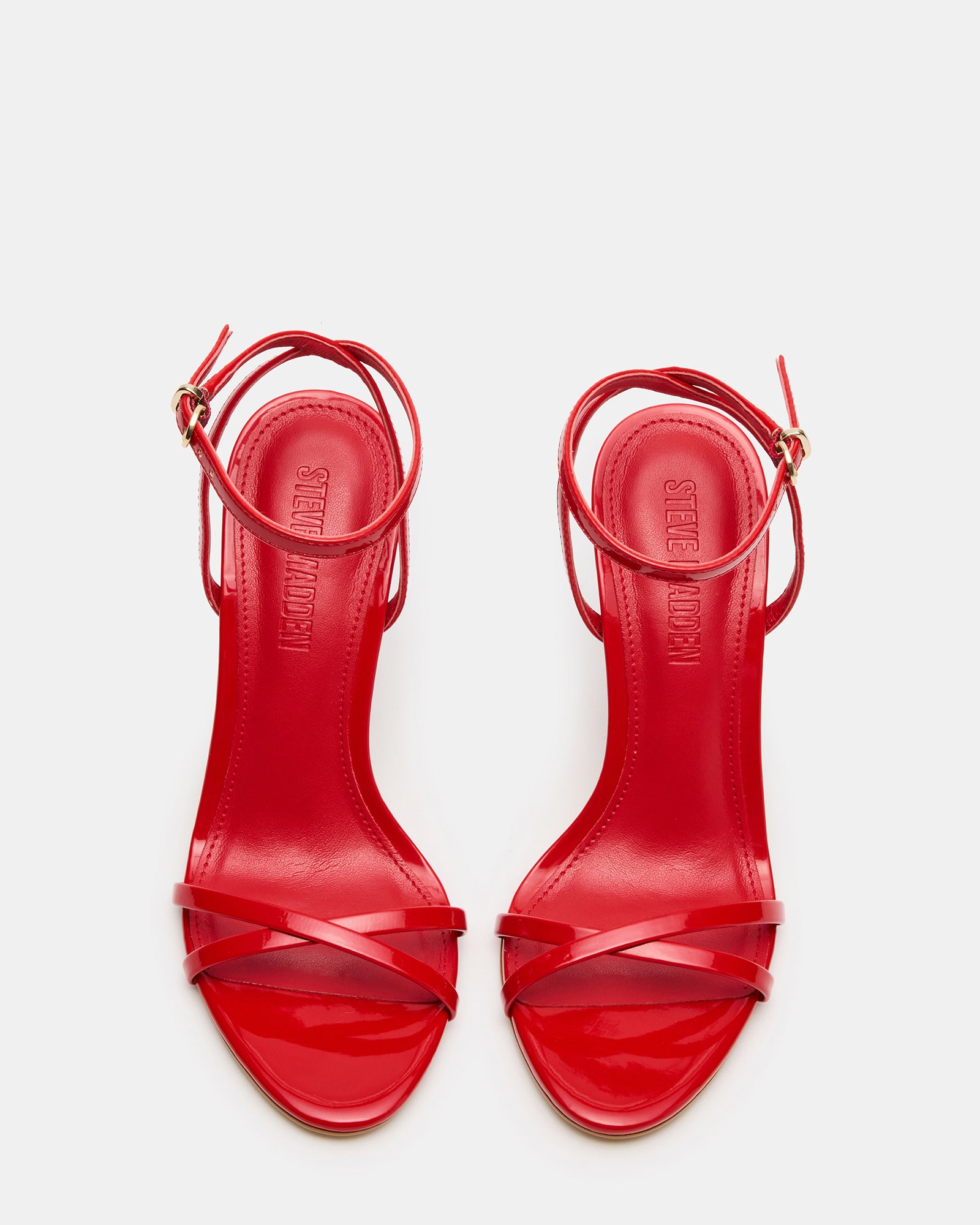 Close-up of red patent leather high heels showing strappy detail
