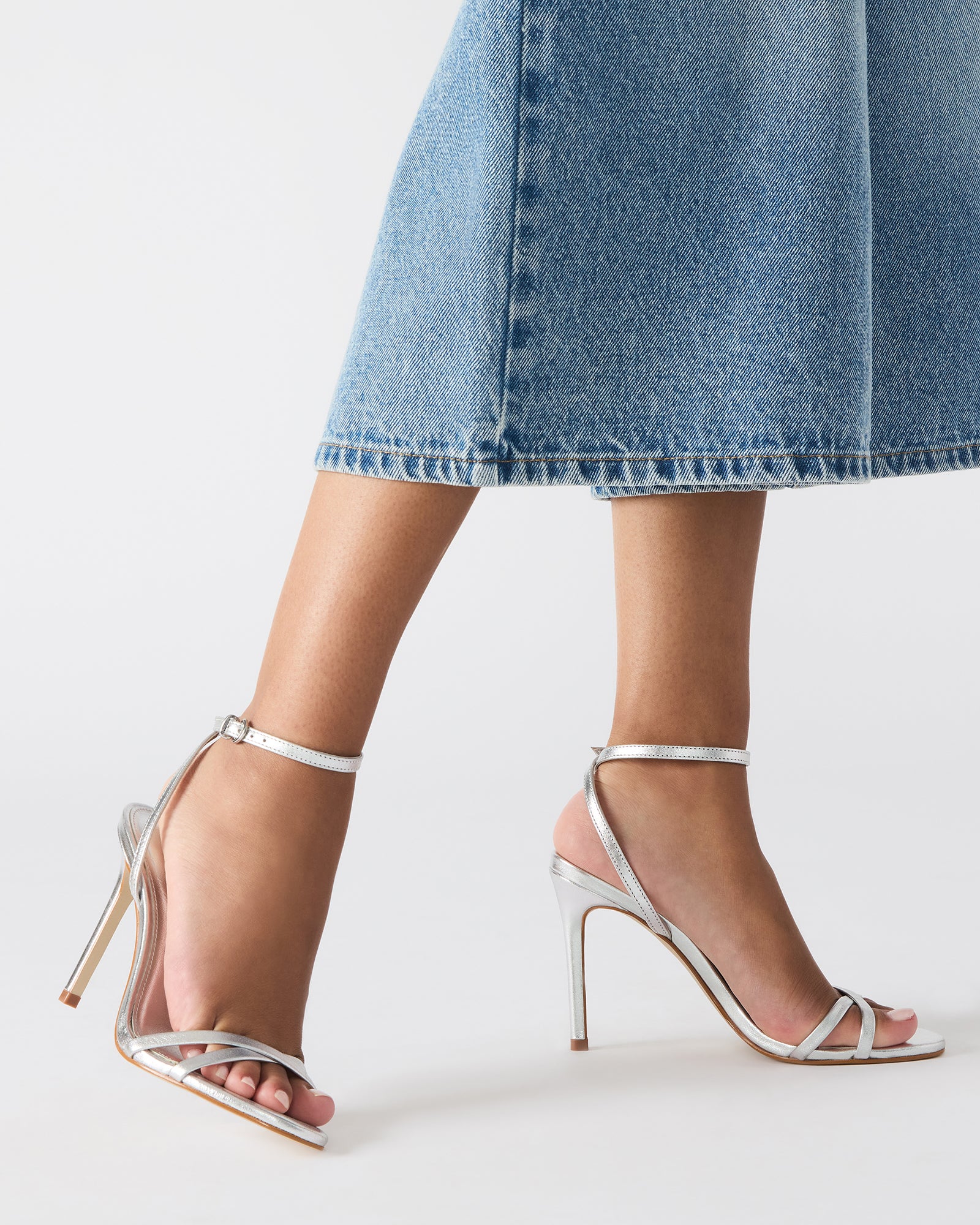 Close-up of stiletto heel and crisscross back detailing on these black heels.
