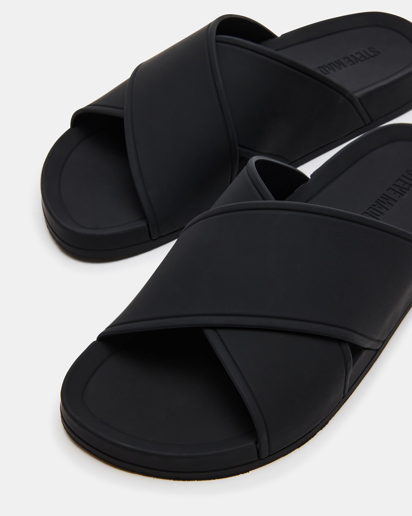 Side view of KATELYN black slide sandals showcasing criss-cross design.