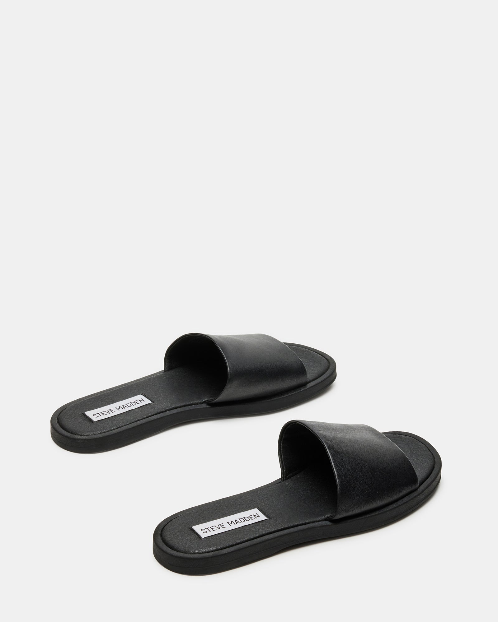 Kaya black leather sandals worn casually in an outdoor setting.