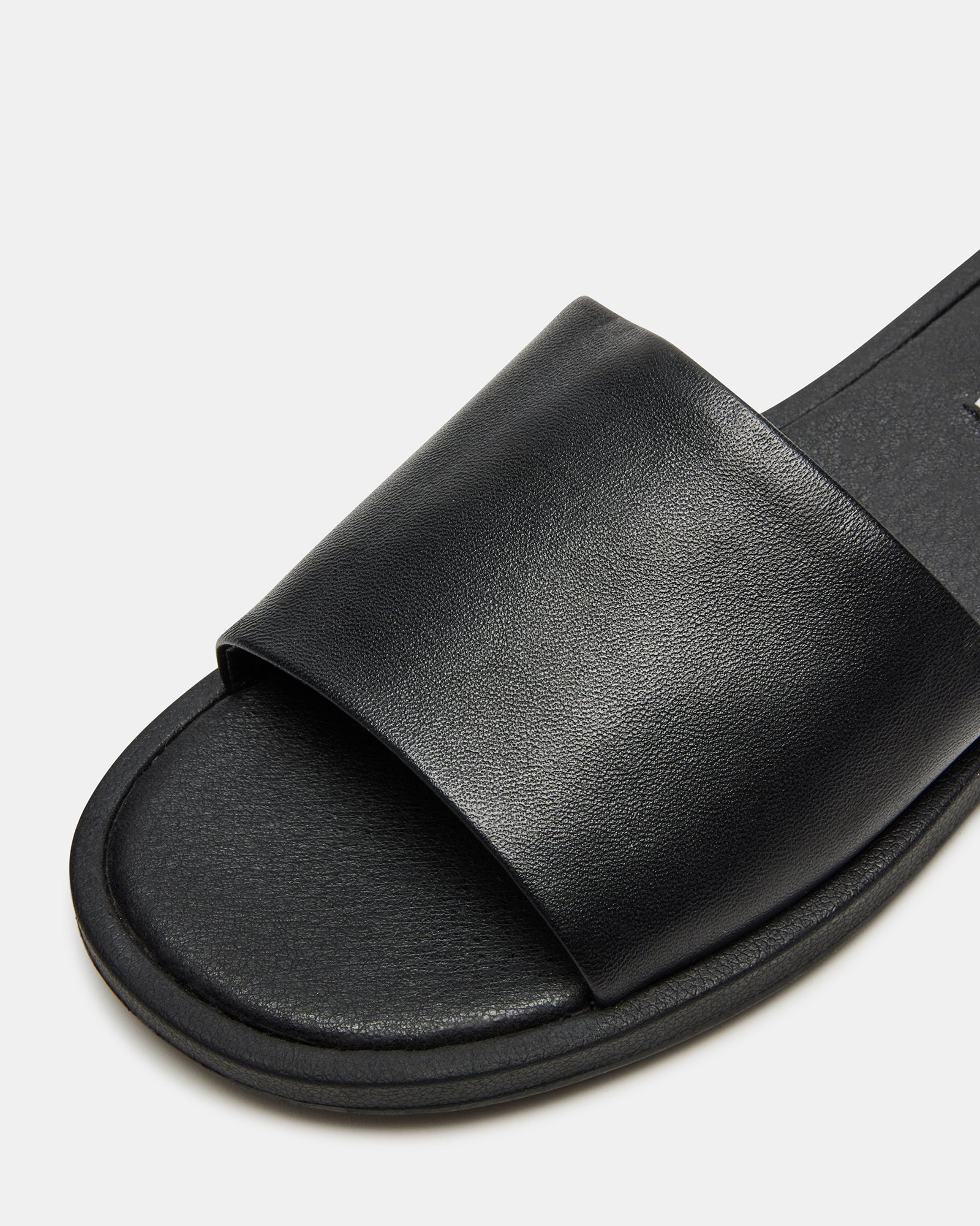 Close-up of the wide strap on Kaya black leather slide sandals.