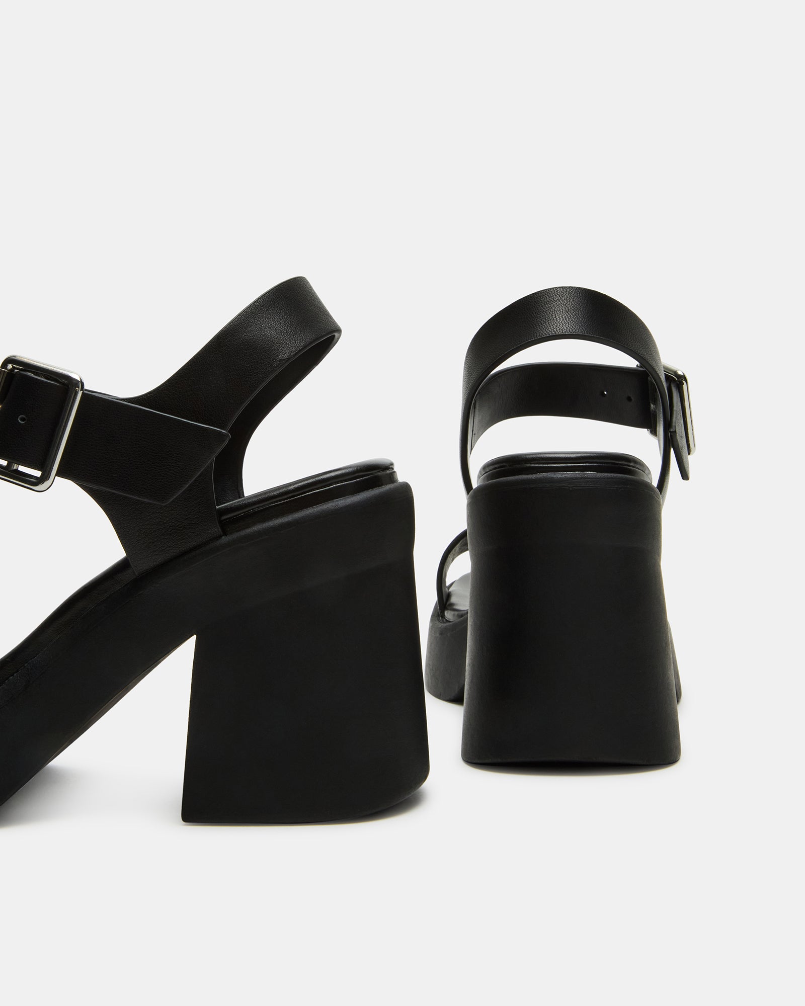 Side angle view of black leather sandals showing ankle strap and block heel