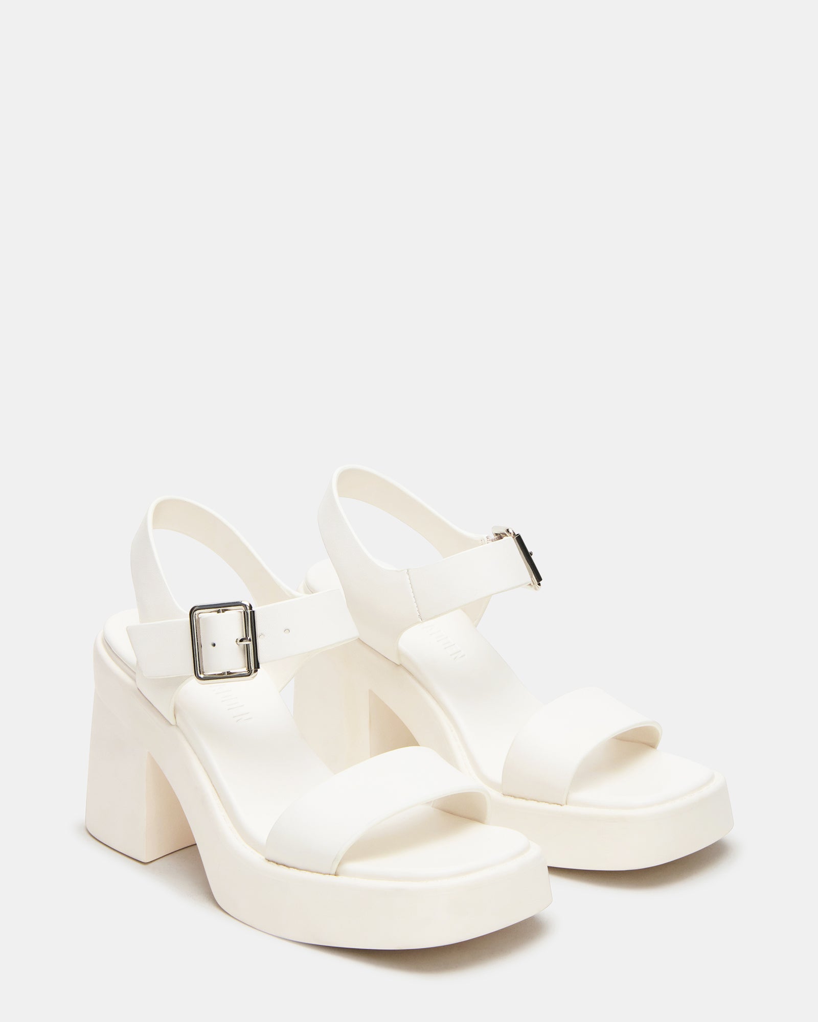 Woman wearing nude block heel sandals in a casual outdoor setting