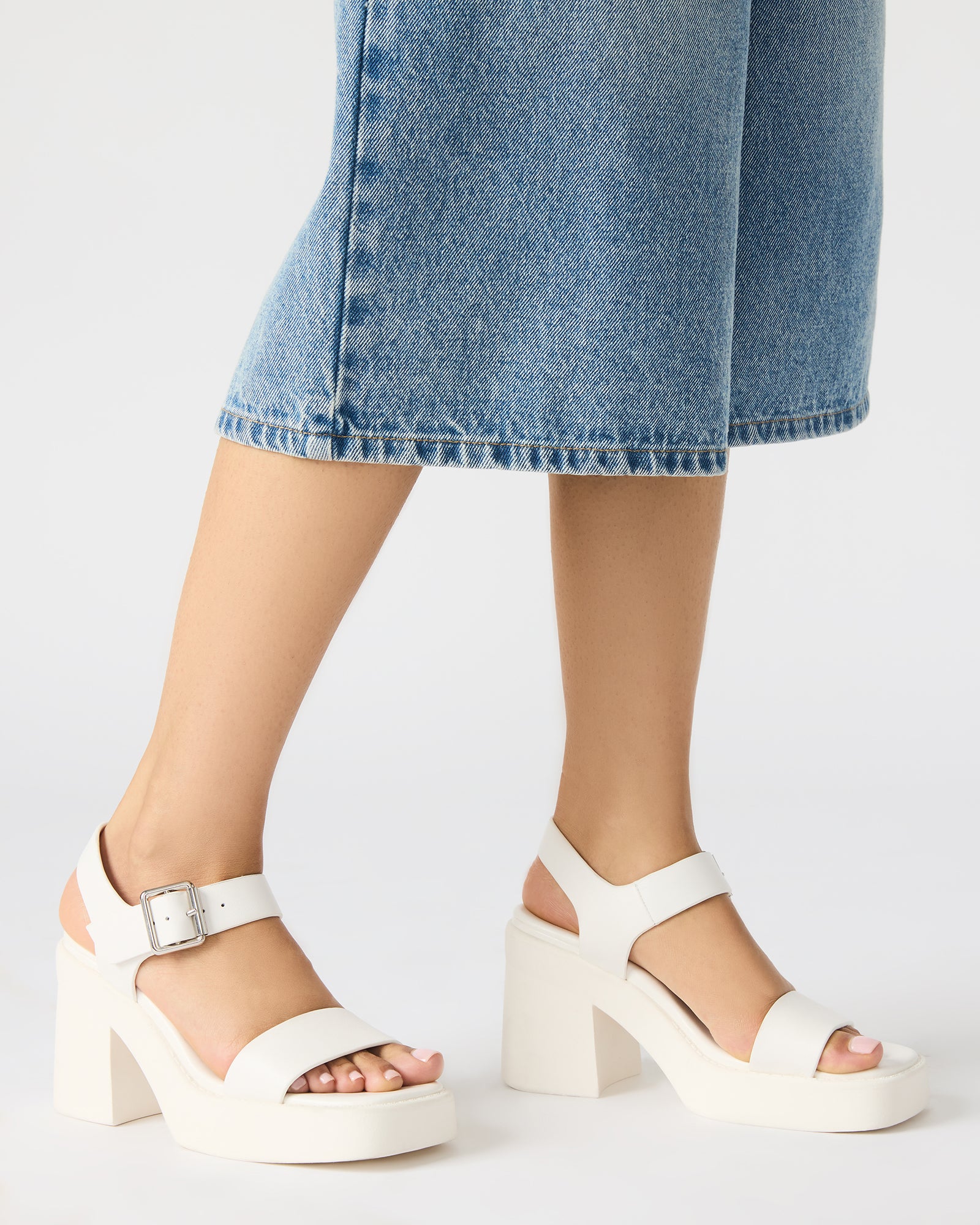 Close-up of ankle strap detail on black leather sandals