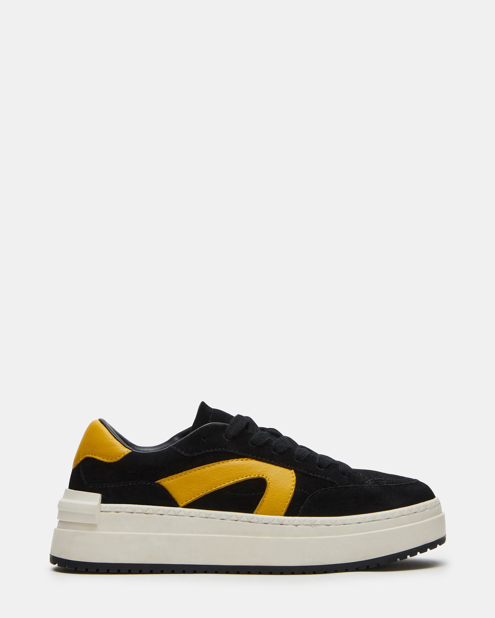 Side angle of black suede platform sneakers, worn casually with jeans