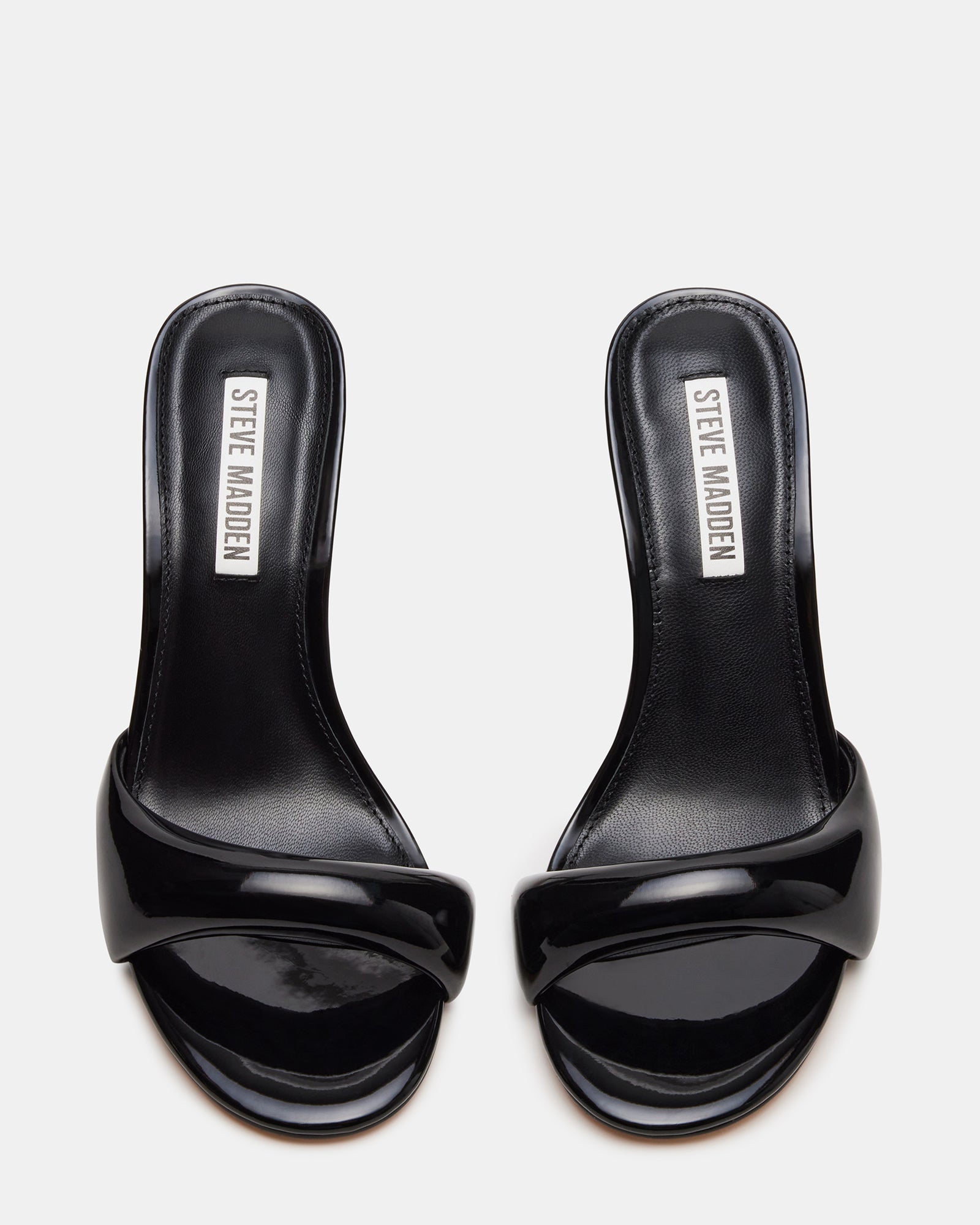 Stylish black patent heels worn at a chic outdoor event.