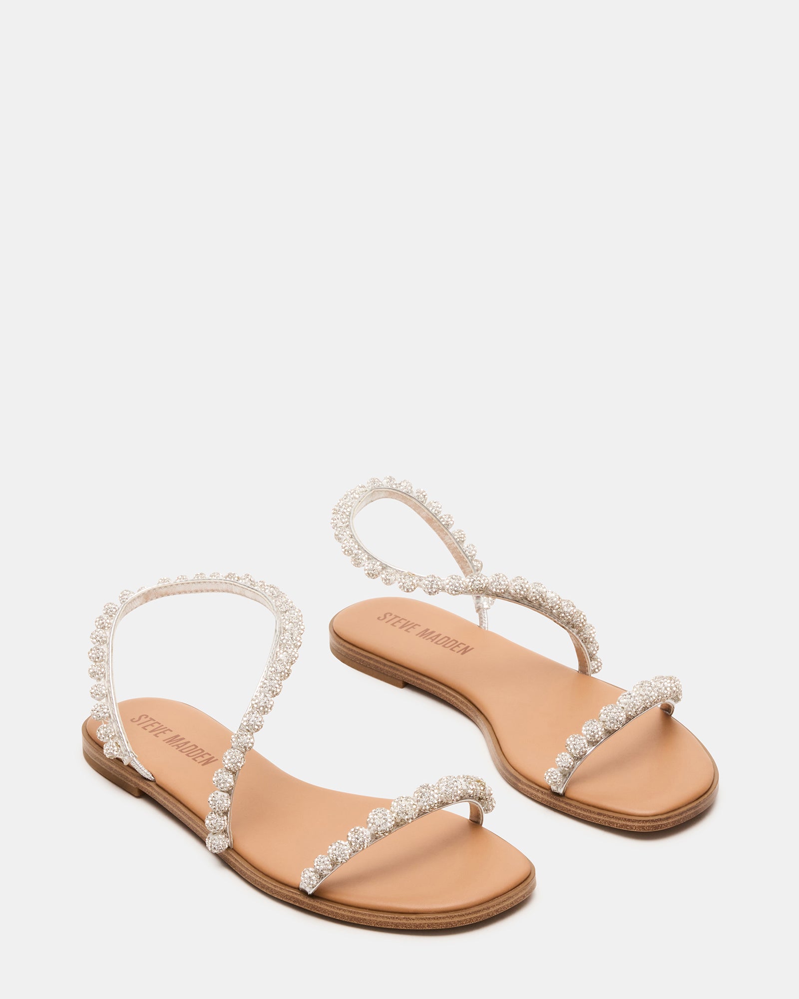 Close-up of adjustable straps and stone embellishments on flat sandals