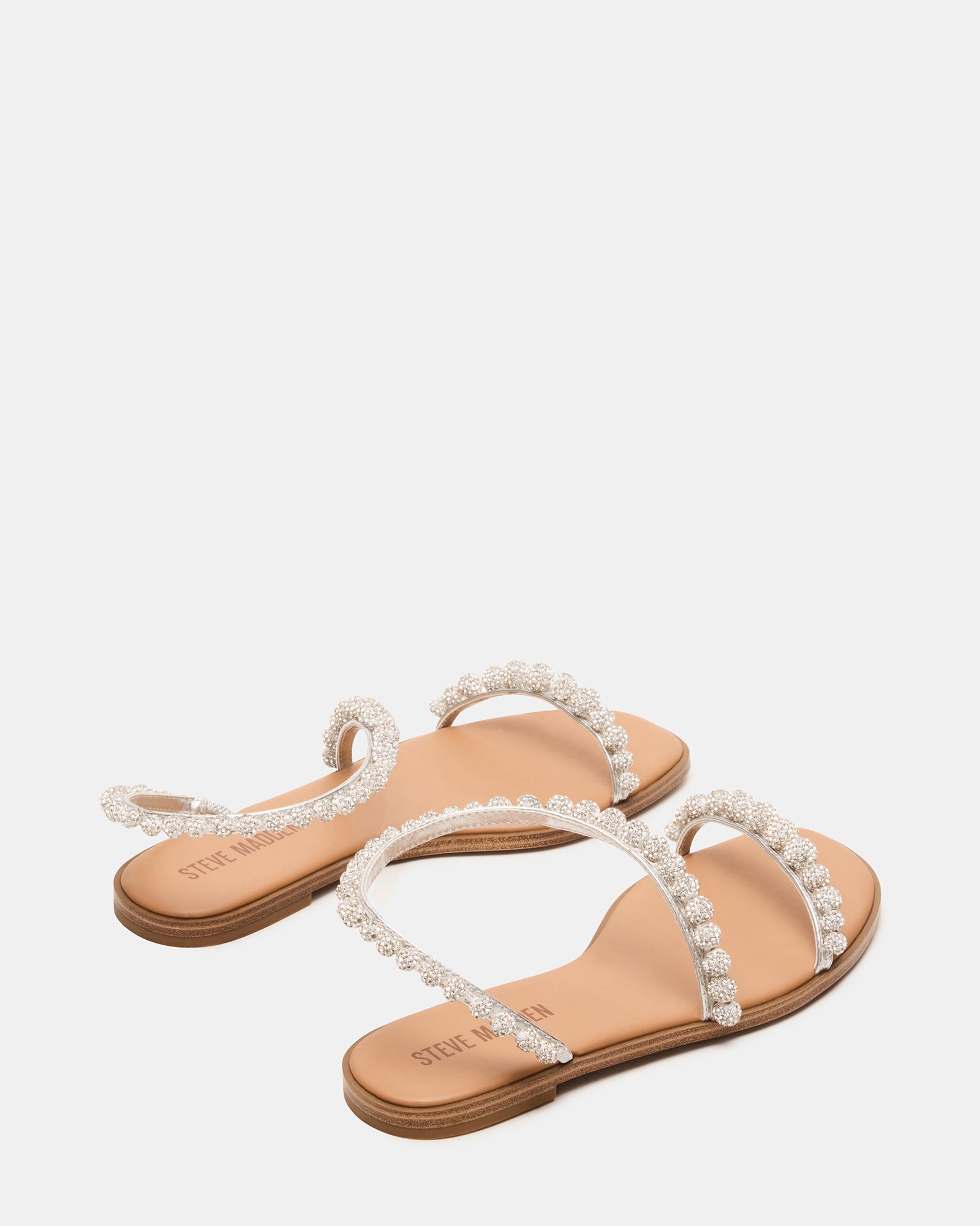 Close-up of adjustable straps and stone embellishments on flat sandals