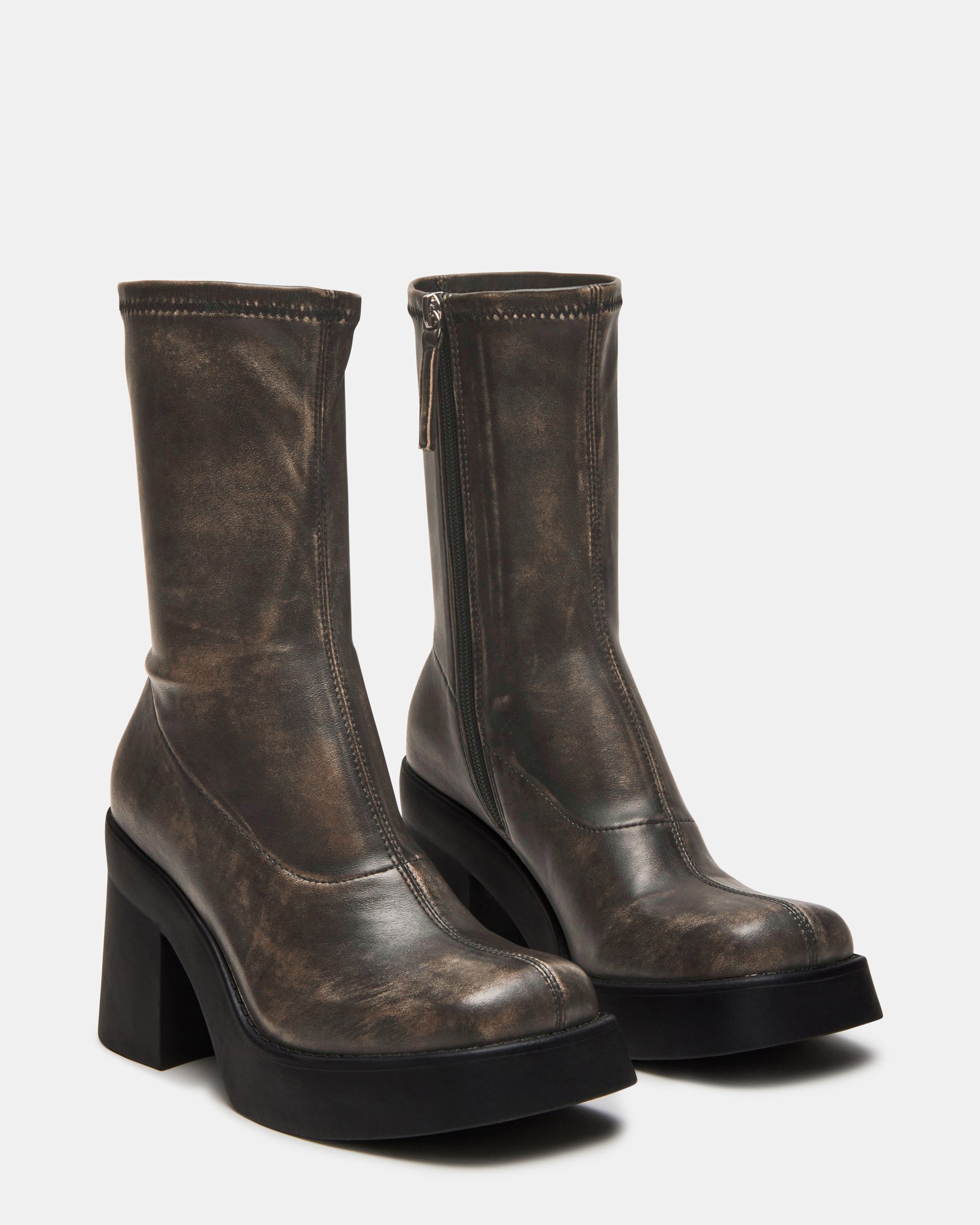 Close-up of the platform sole and heel of brown mid calf boots emphasizing the retro style.