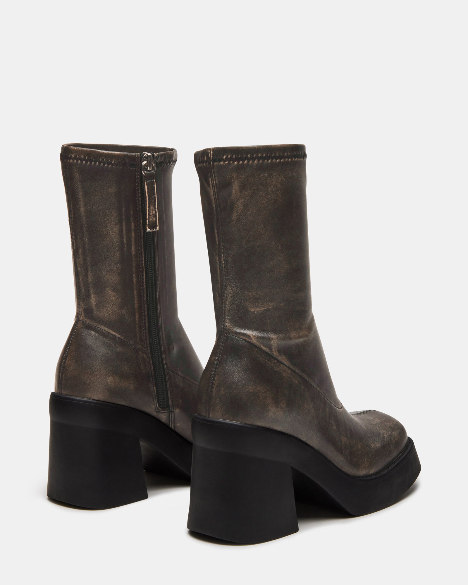 Close-up of the platform sole and heel of brown mid calf boots emphasizing the retro style.