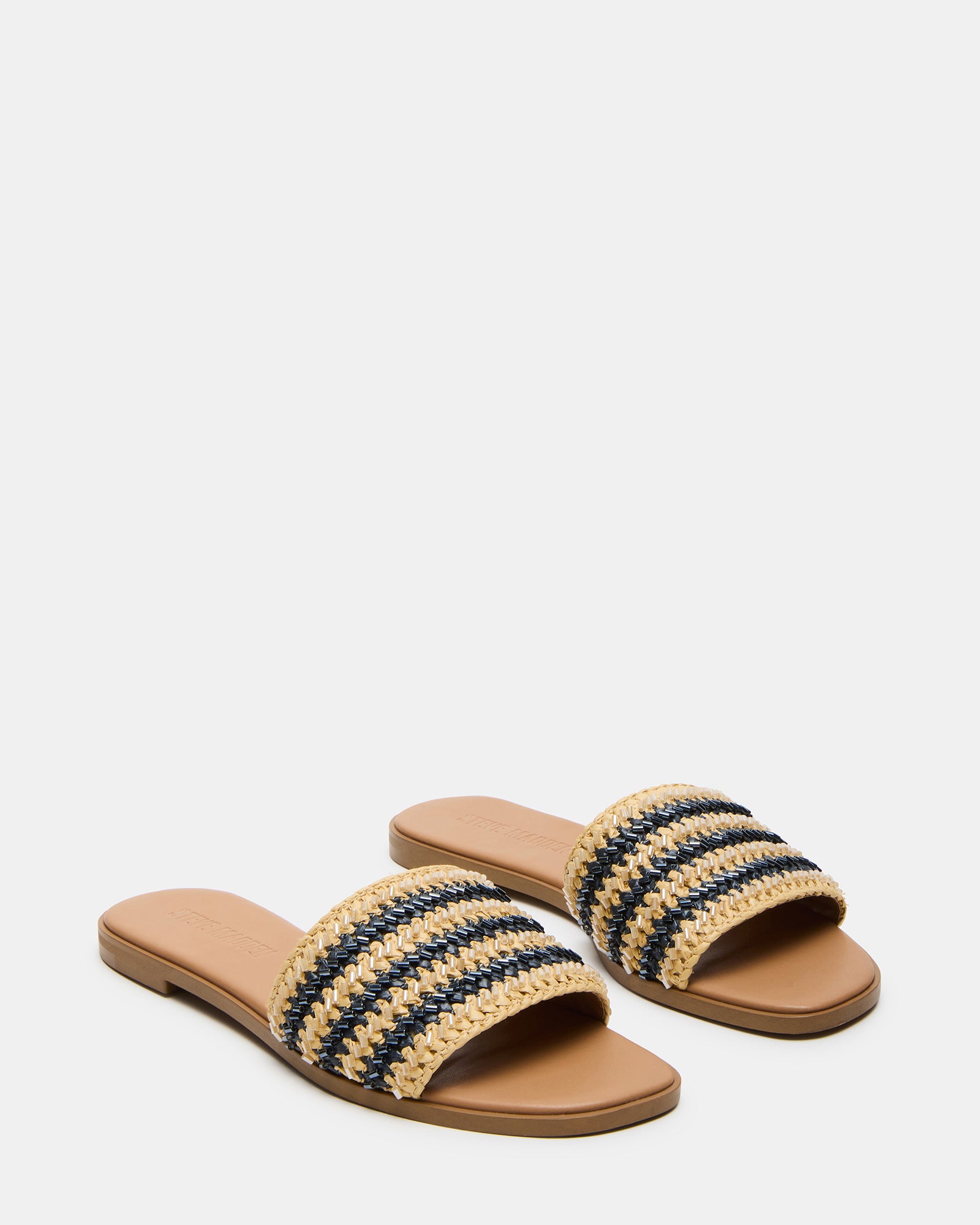 Overhead shot of comfortable sandals laid out beside summer accessories for a beach getaway