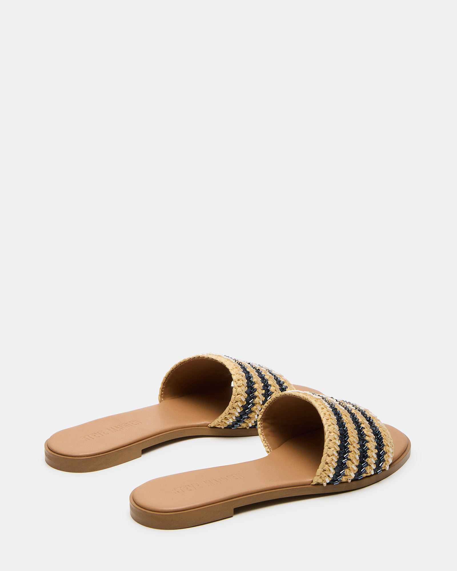 Overhead shot of comfortable sandals laid out beside summer accessories for a beach getaway
