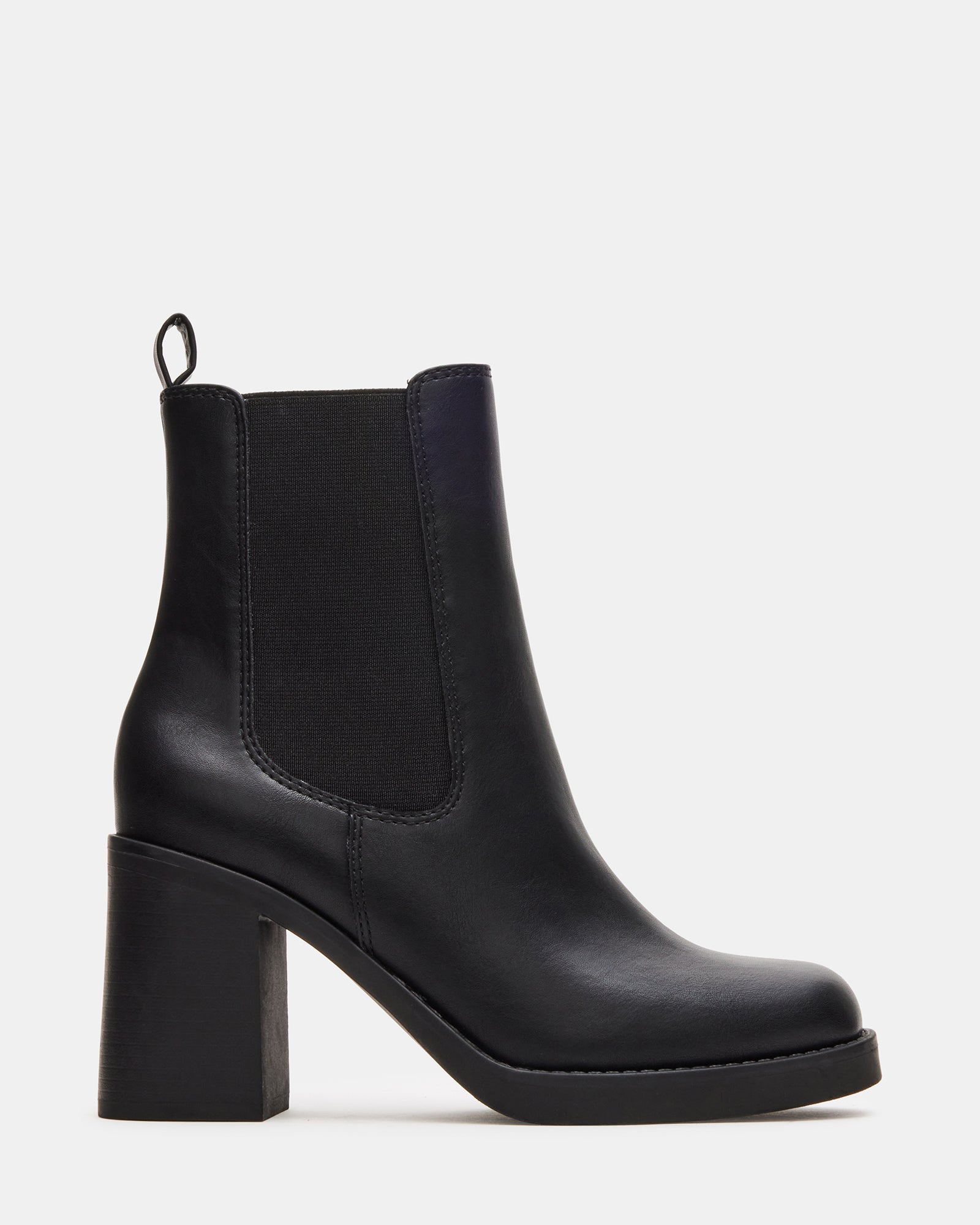 Side view of black ankle boots styled with denim for city wear