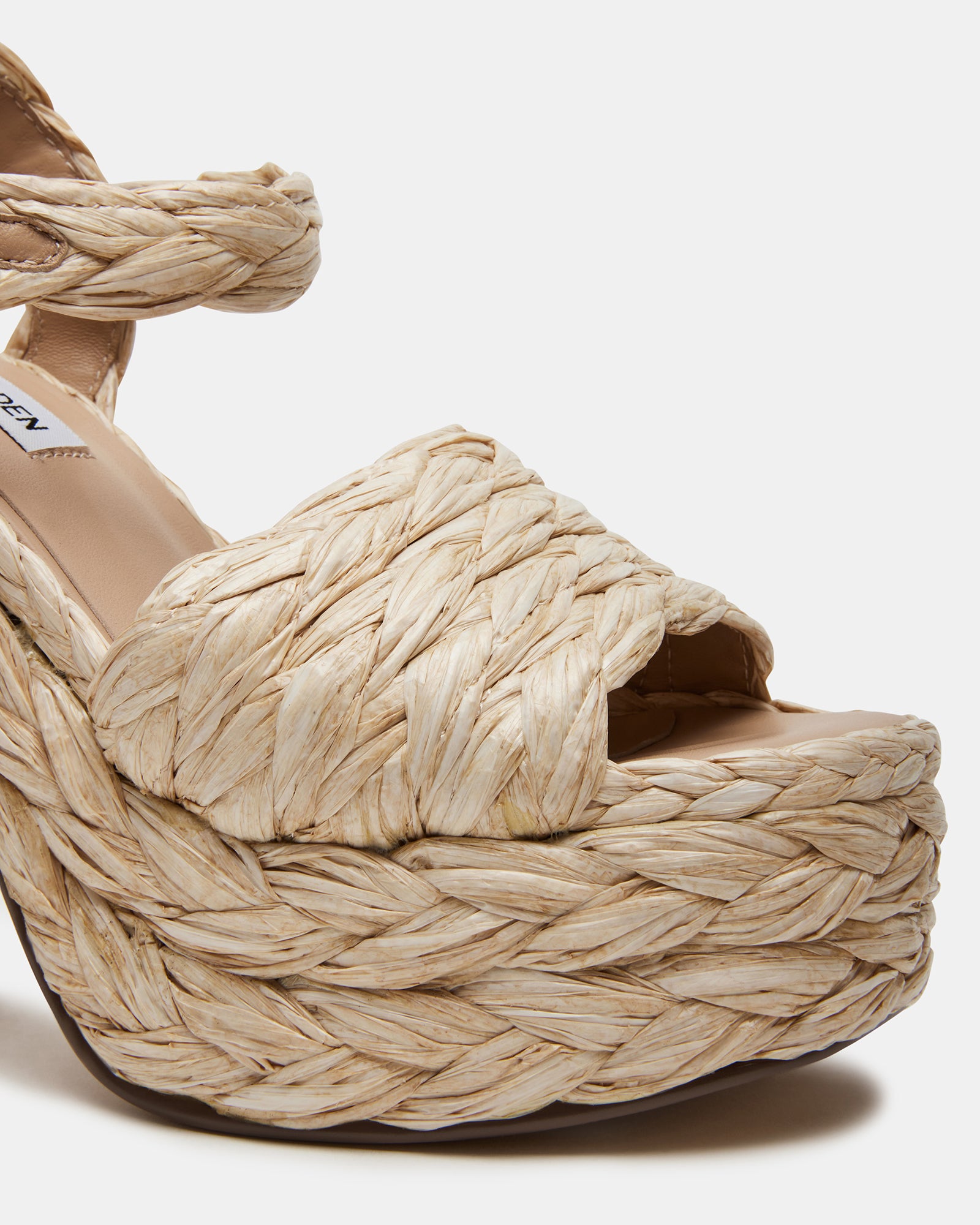 Koral Luxe Raffia Platform Heels displayed on a polished surface.