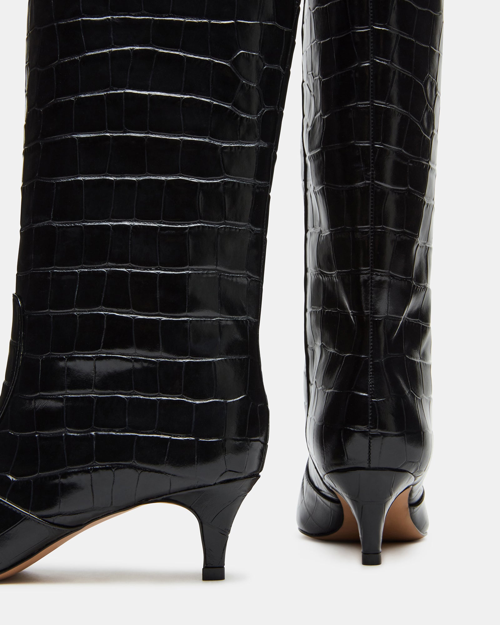 Angled view of black square toe knee high boots with a kitten heel.