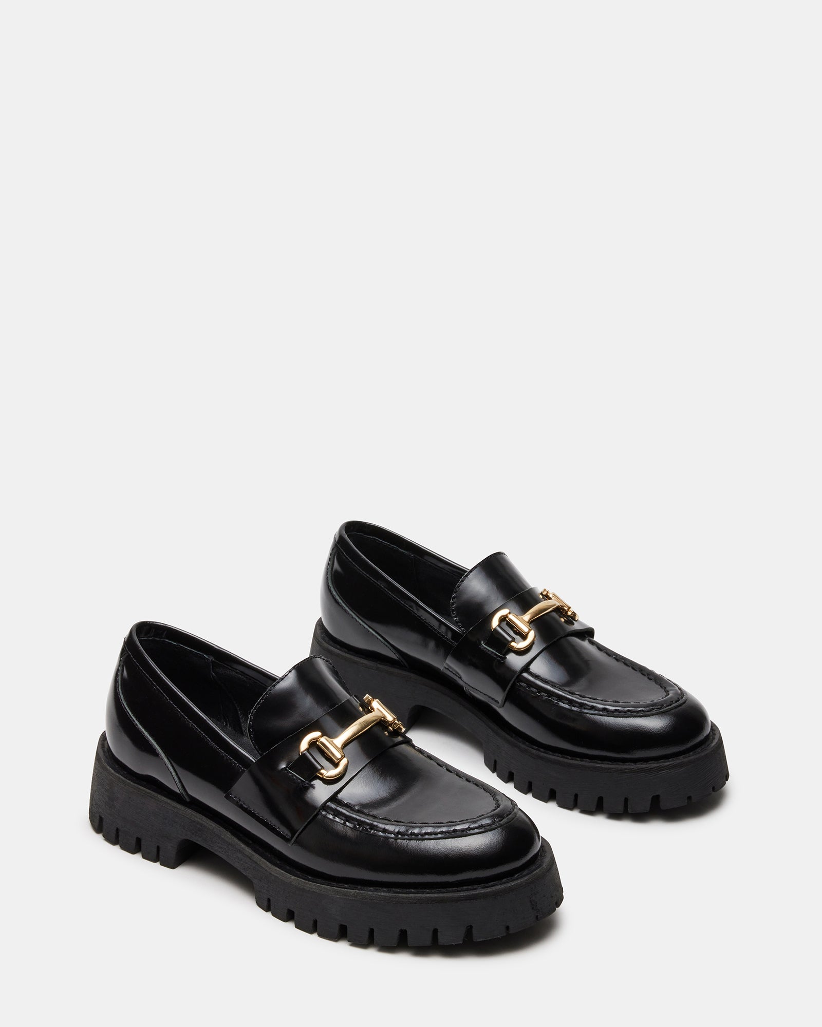 Black leather platform loafers with horsebit hardware showing the chunky sole detail