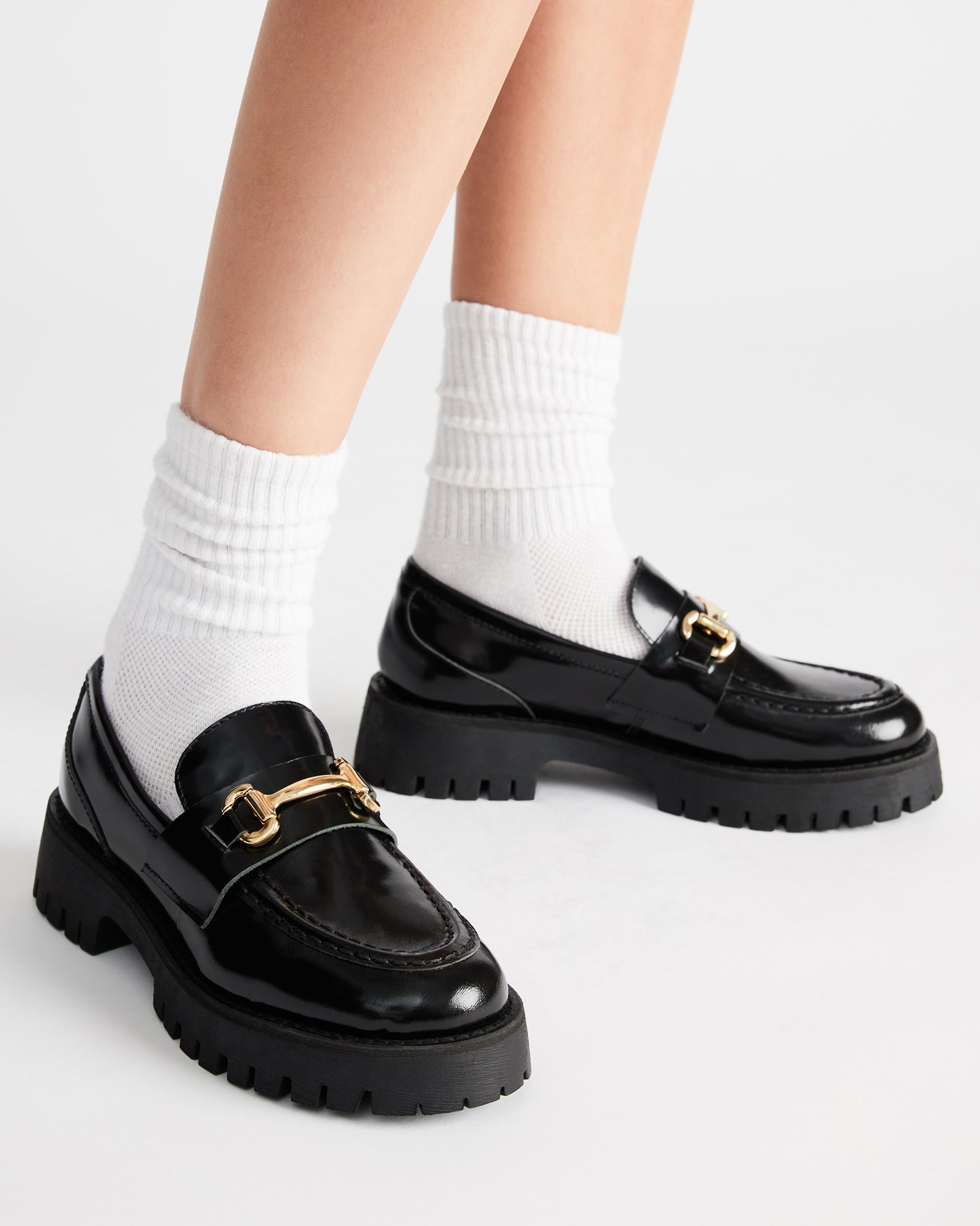 Side view of womens black platform loafers with classic hardware and lug sole