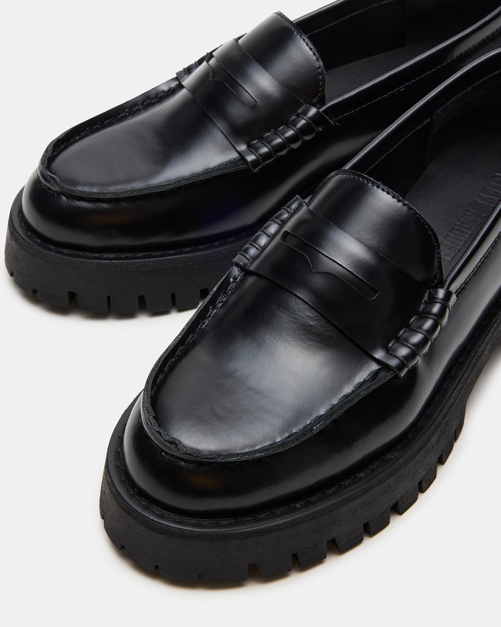 Langsten black platform loafers from a side angle, showcasing the lug sole tread