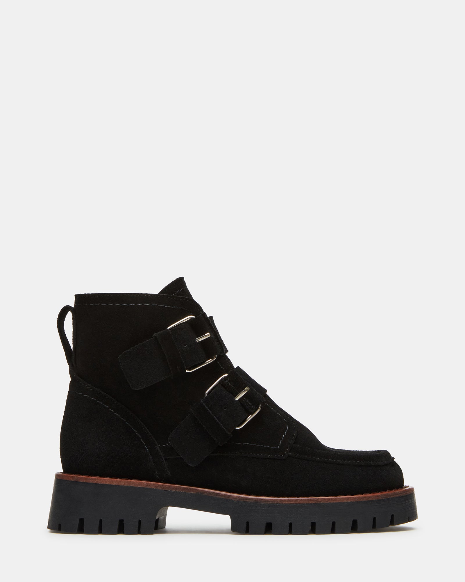 Side view of black suede ankle boots with bold buckles and rugged lug sole