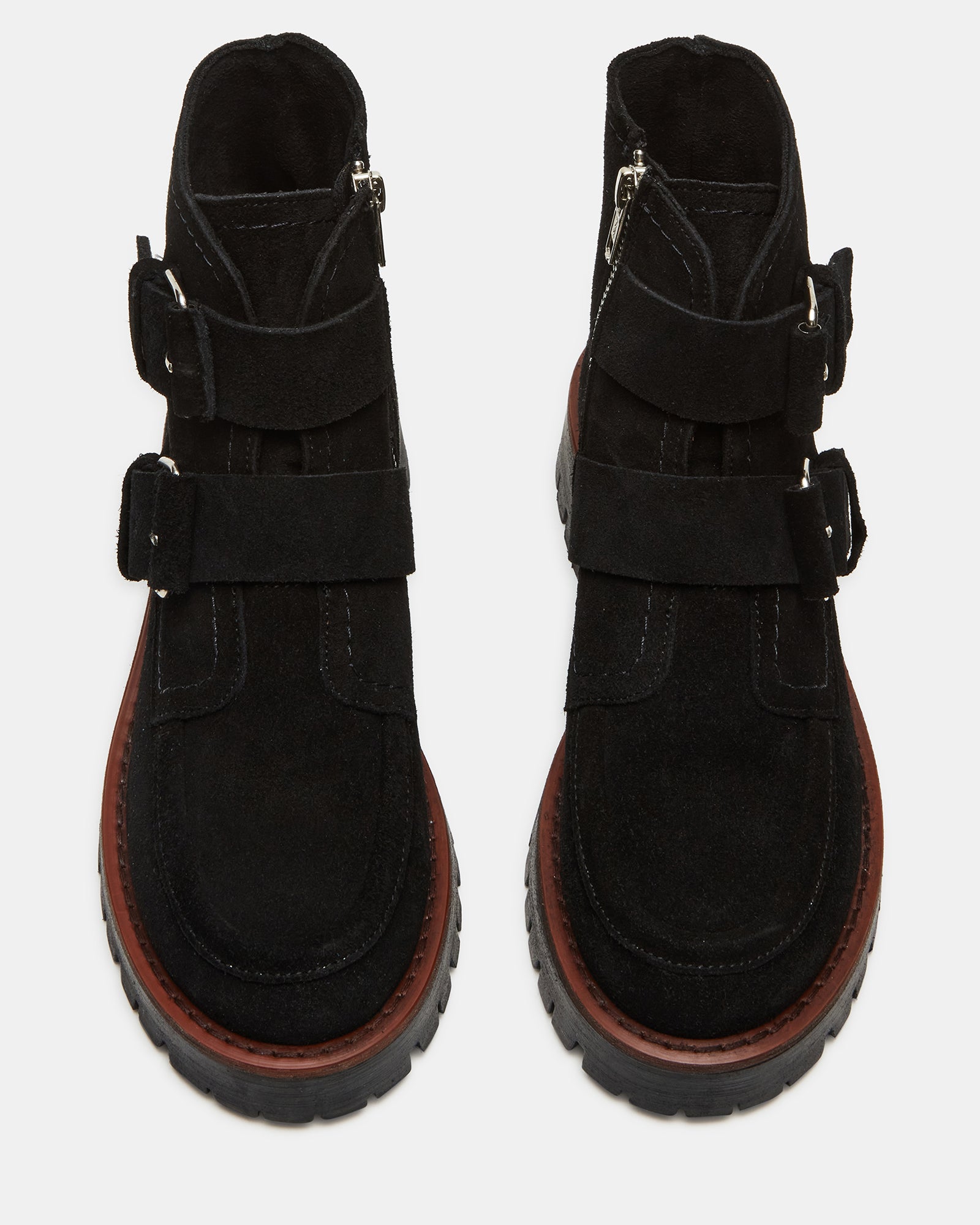 Side view of black suede ankle boots with bold buckles and rugged lug sole