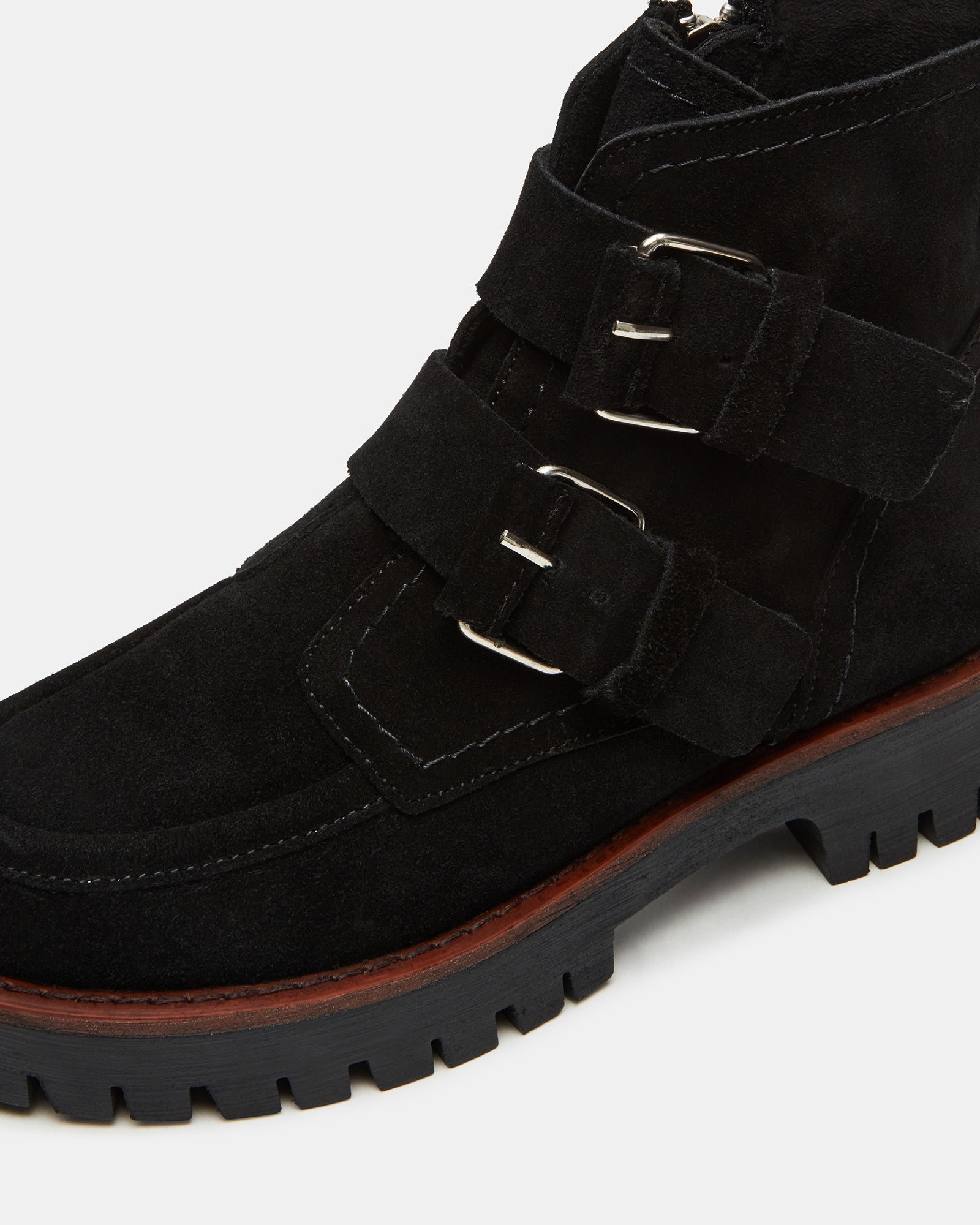 Close-up of lug sole chelsea boots detailing textured tread and suede finish