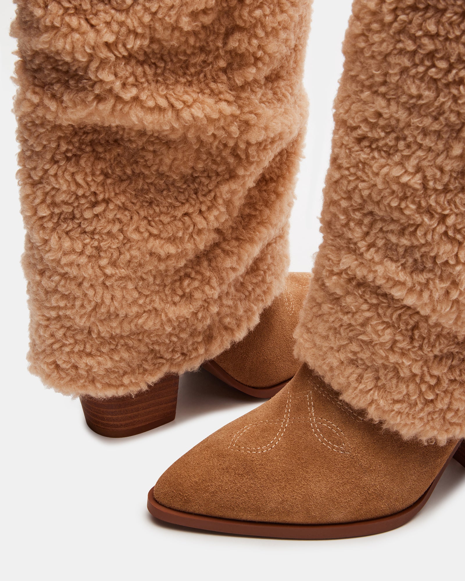 Side angle view of brown knee high boots with slouchy faux fur cuffs