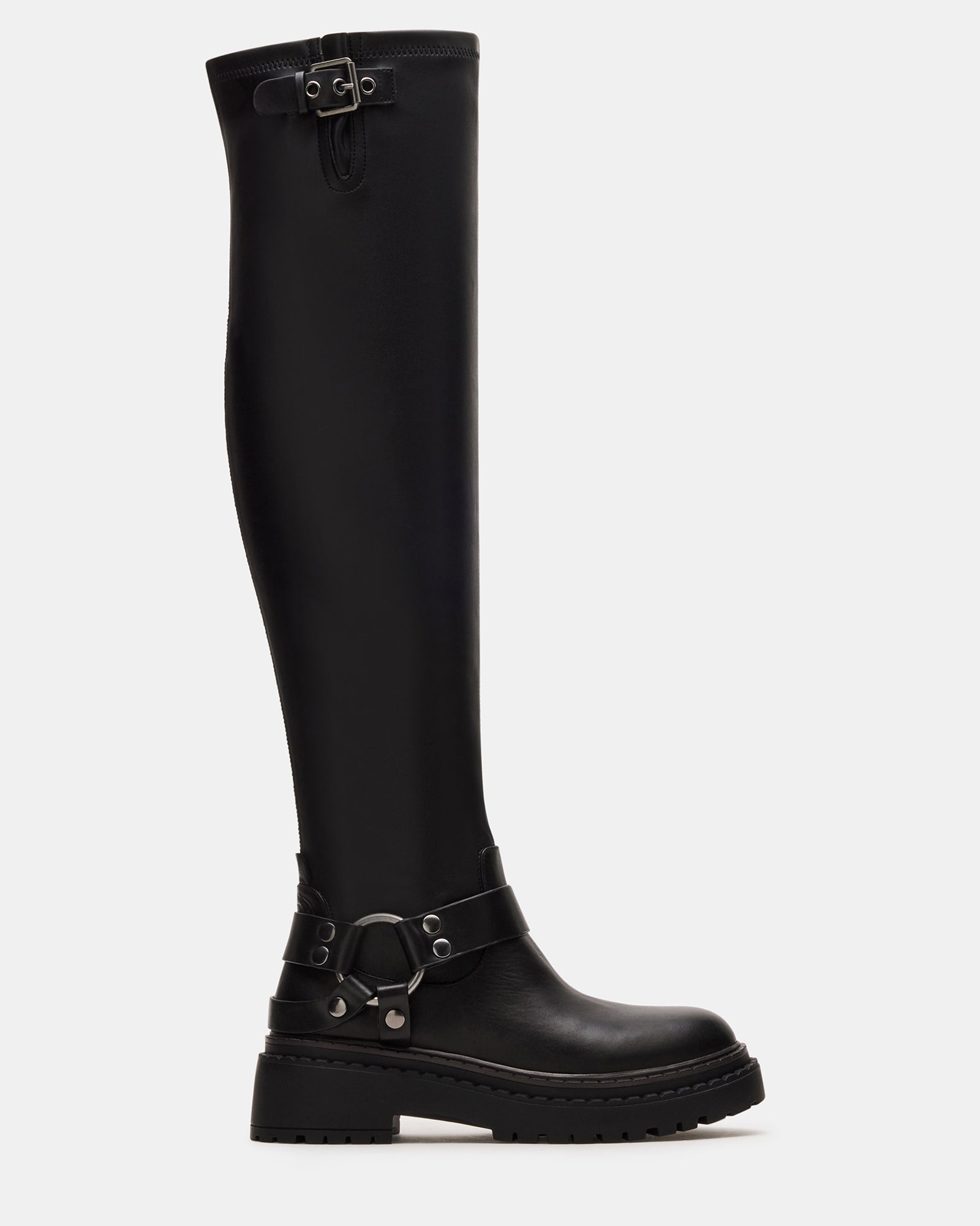 Front angle of black over the knee boots styled with denim on urban steps