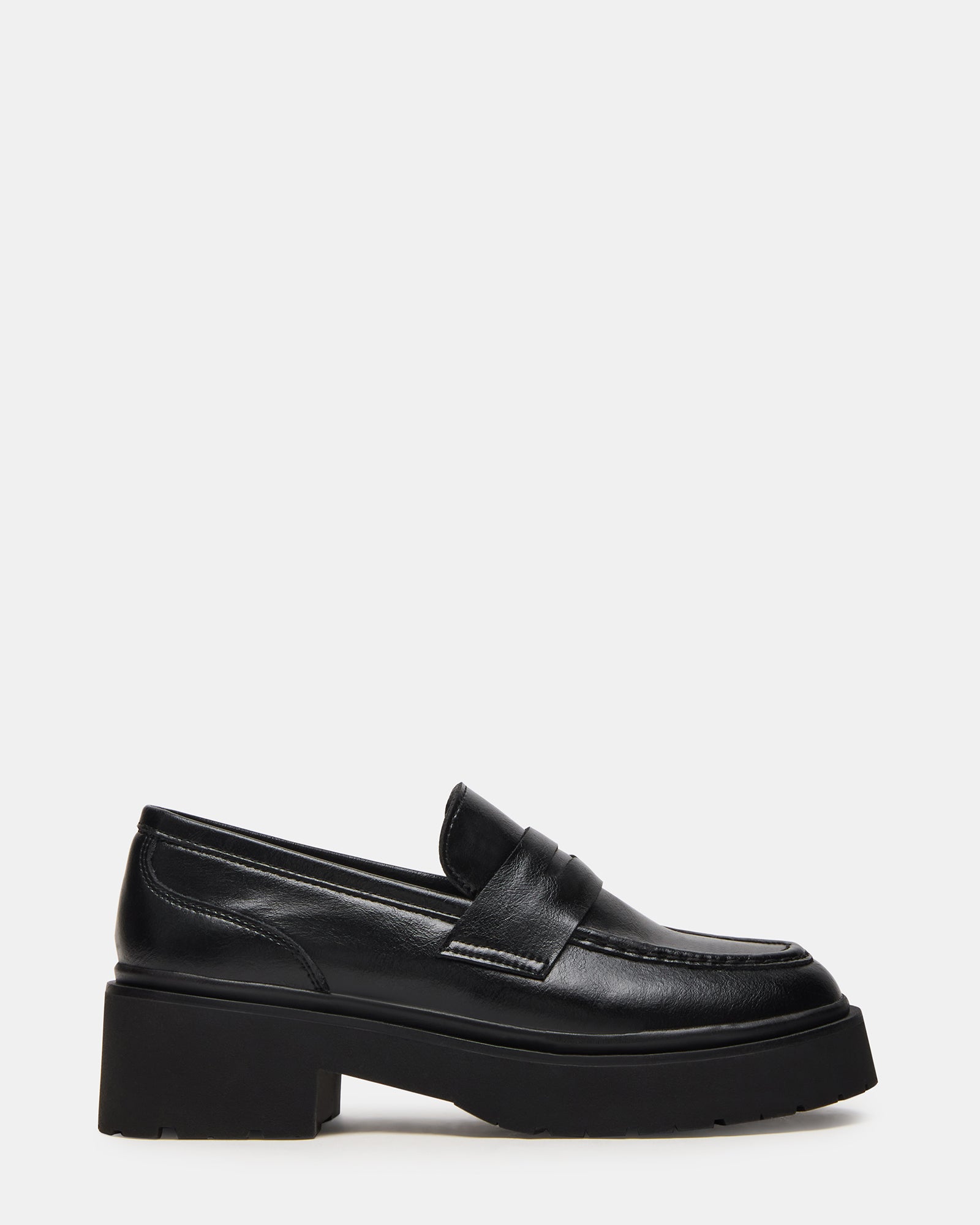 Side view of black leather loafers with lug sole on a city street