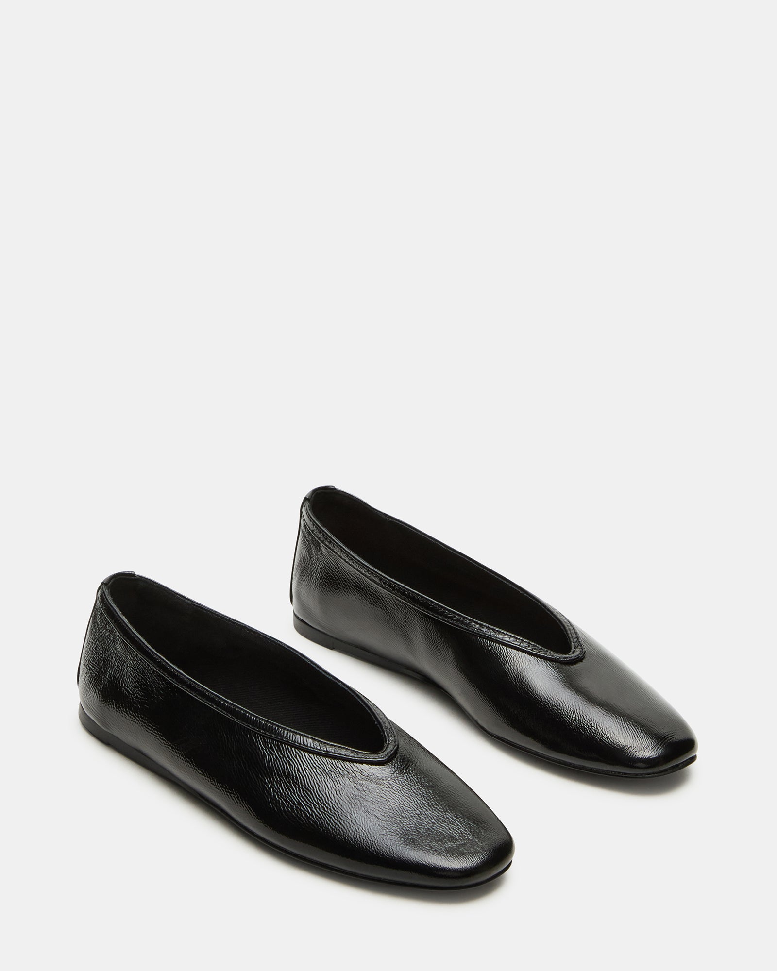 Lifestyle photo of black ballet ballerina flats worn on city sidewalk