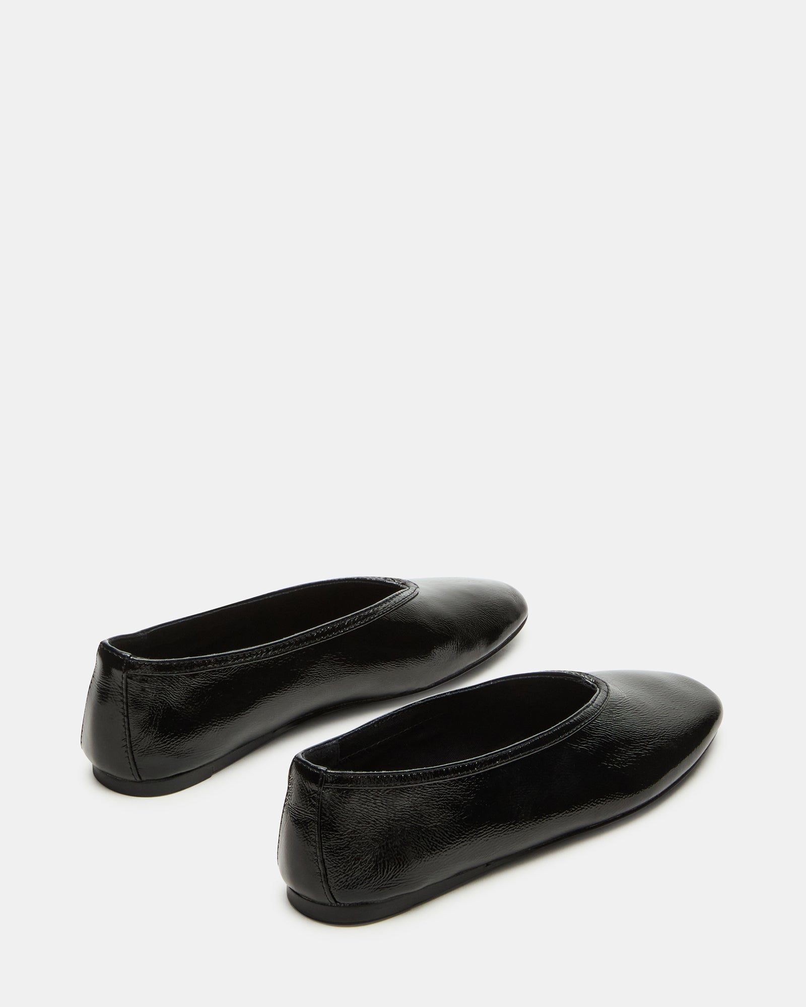 Lifestyle photo of black ballet ballerina flats worn on city sidewalk