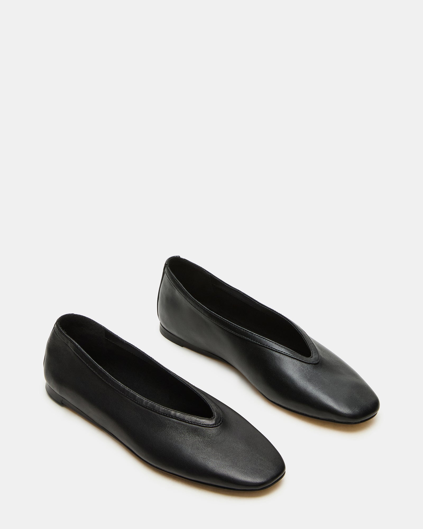 Close-up of the luxurious leather upper of black square toe ballet flats.