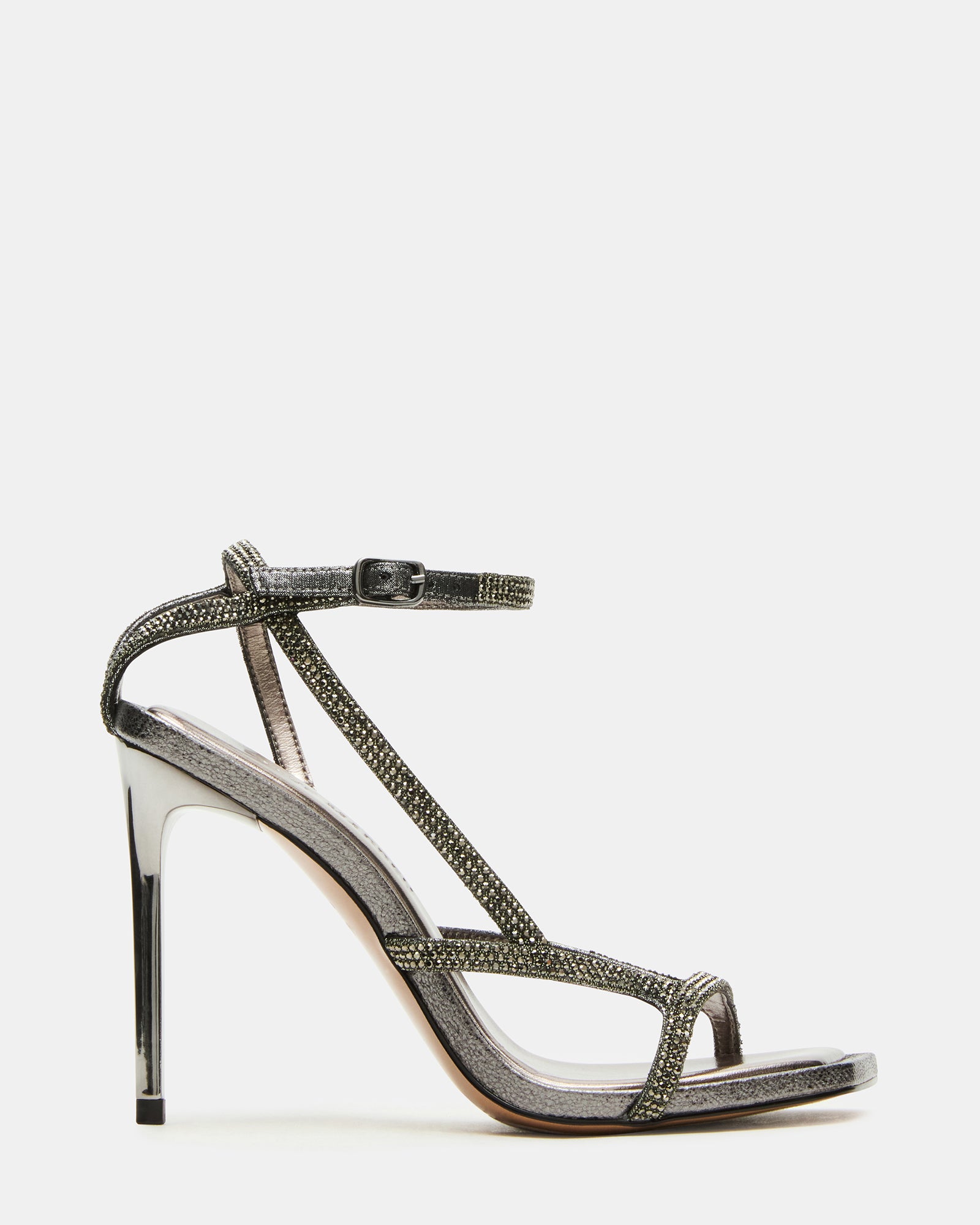 Side view of LEVIOSA pewter rhinestone stiletto heels with ankle strap on a stylish woman